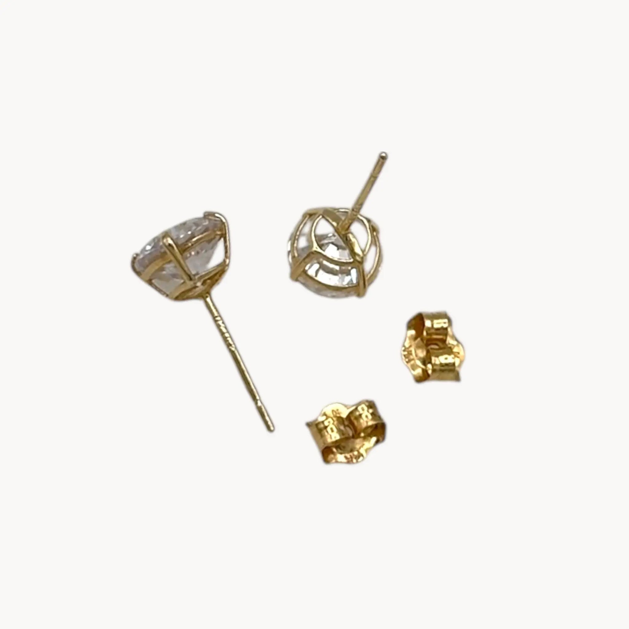 Side and back vie of 14K yellow gold cubic zirconia solitaire stud earrings displayed on white background.