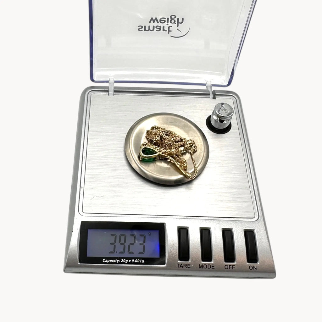 Scale view of Vintage 14K yellow gold teardrop green spinel and diamond pendant necklace.