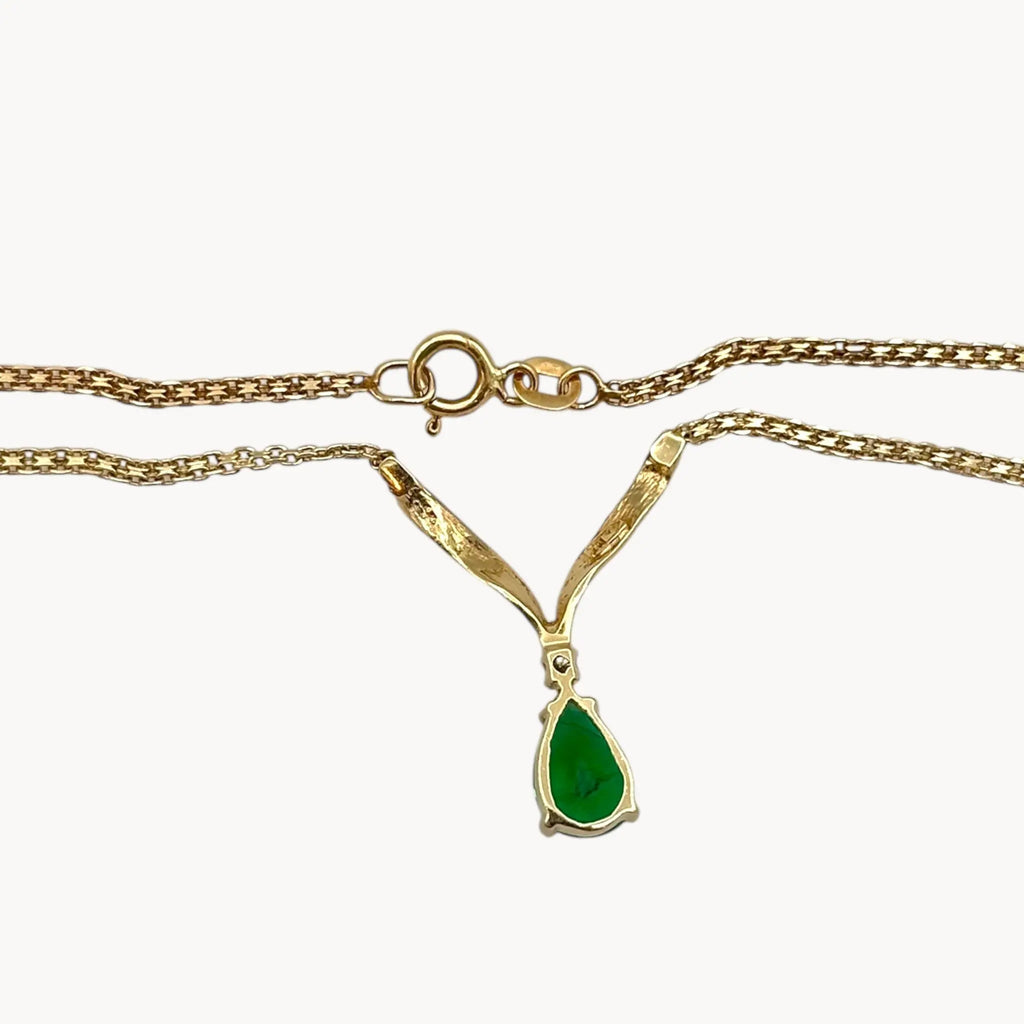 Back view of Vintage 14K yellow gold teardrop green spinel and diamond pendant necklace on white background.