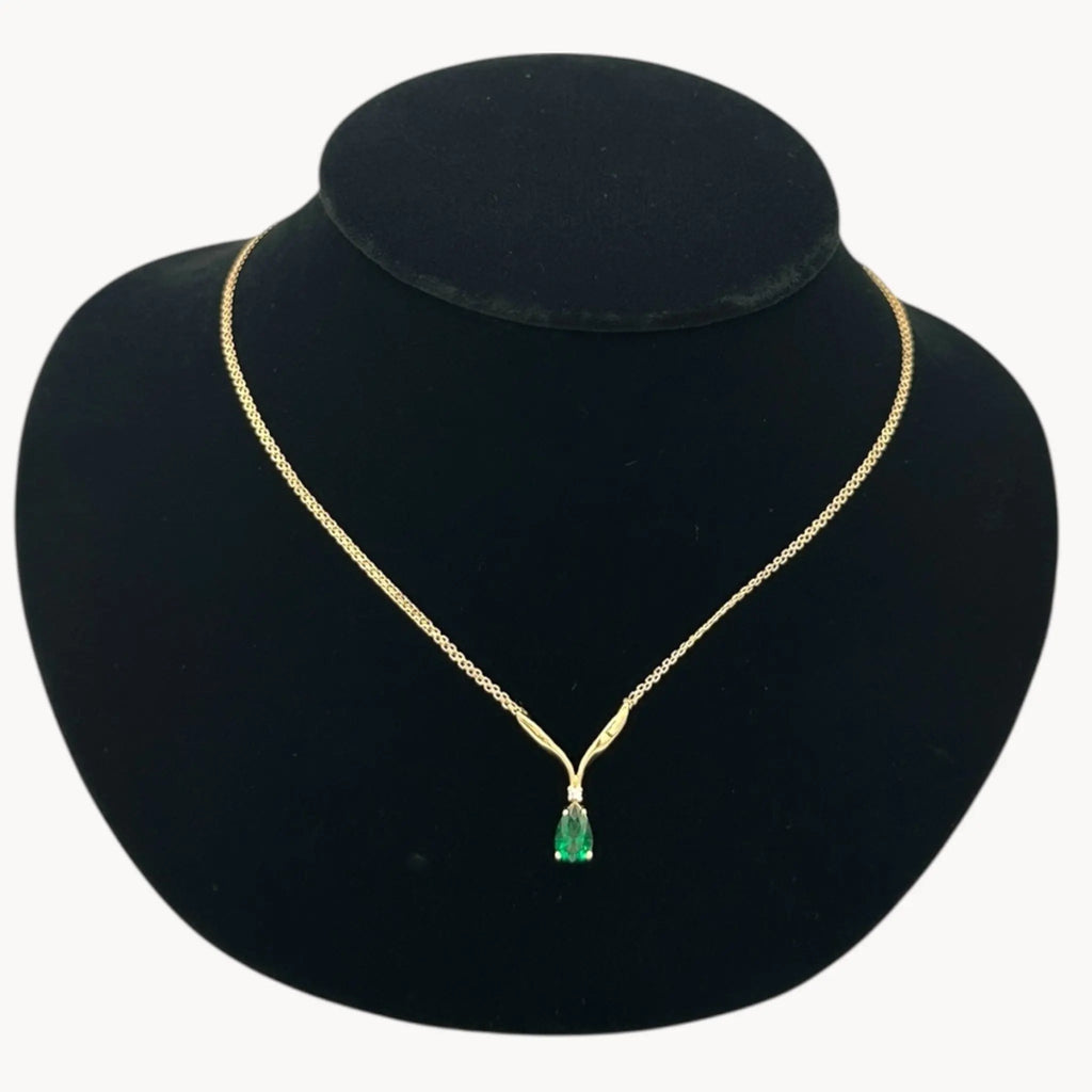 Close up view of Vintage 14K yellow gold teardrop green spinel and diamond pendant necklace.