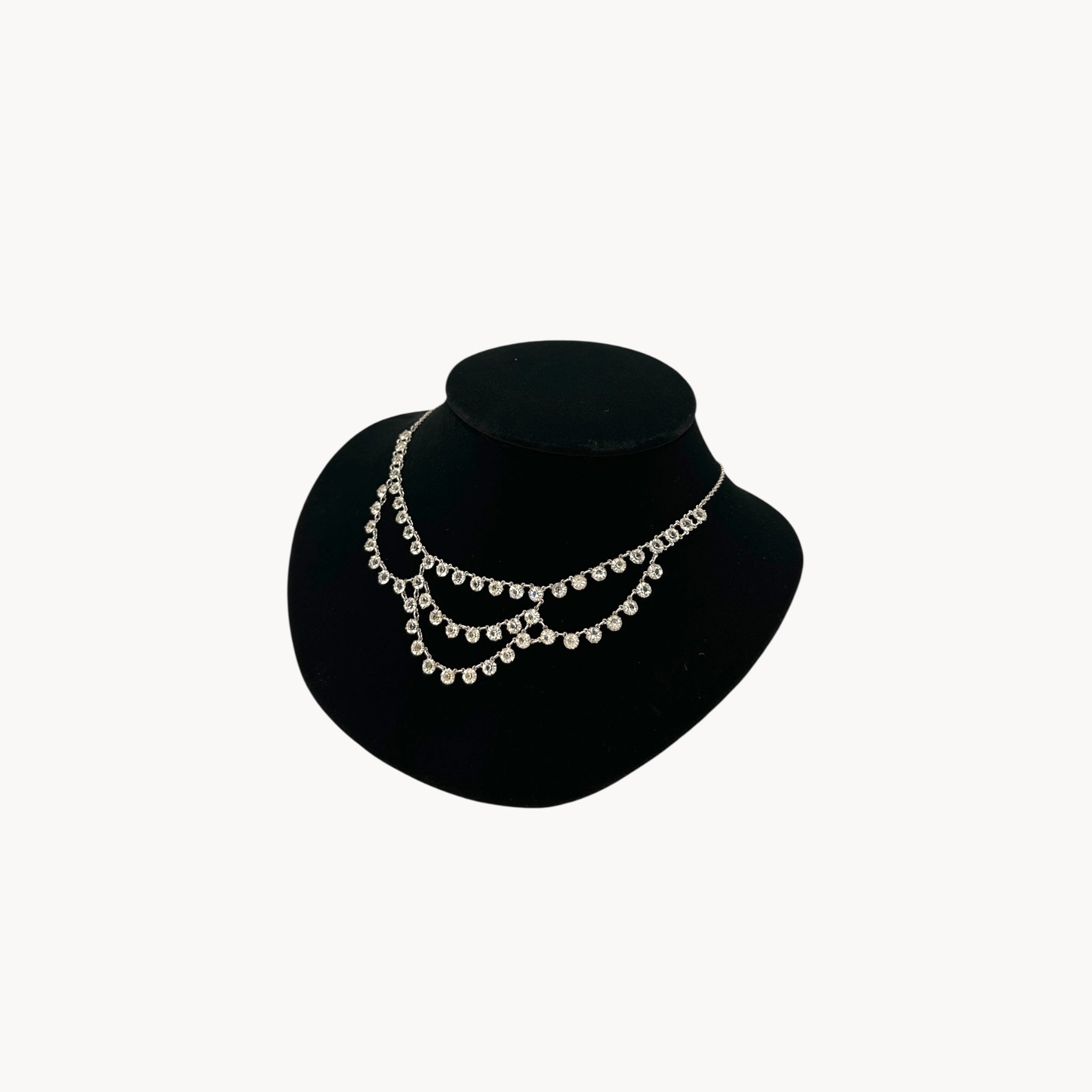 Side view of Art Deco style 12K gold-filled rhodium plated crystal draped necklace on black bust.