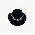 Art Deco style rhodium plated crystal fringe necklace on black bust.