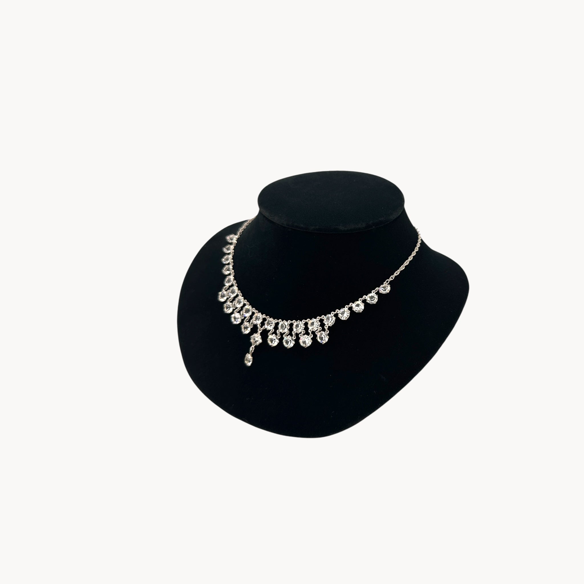 Side view of Art Deco style rhodium plated crystal fringe necklace on black bust.