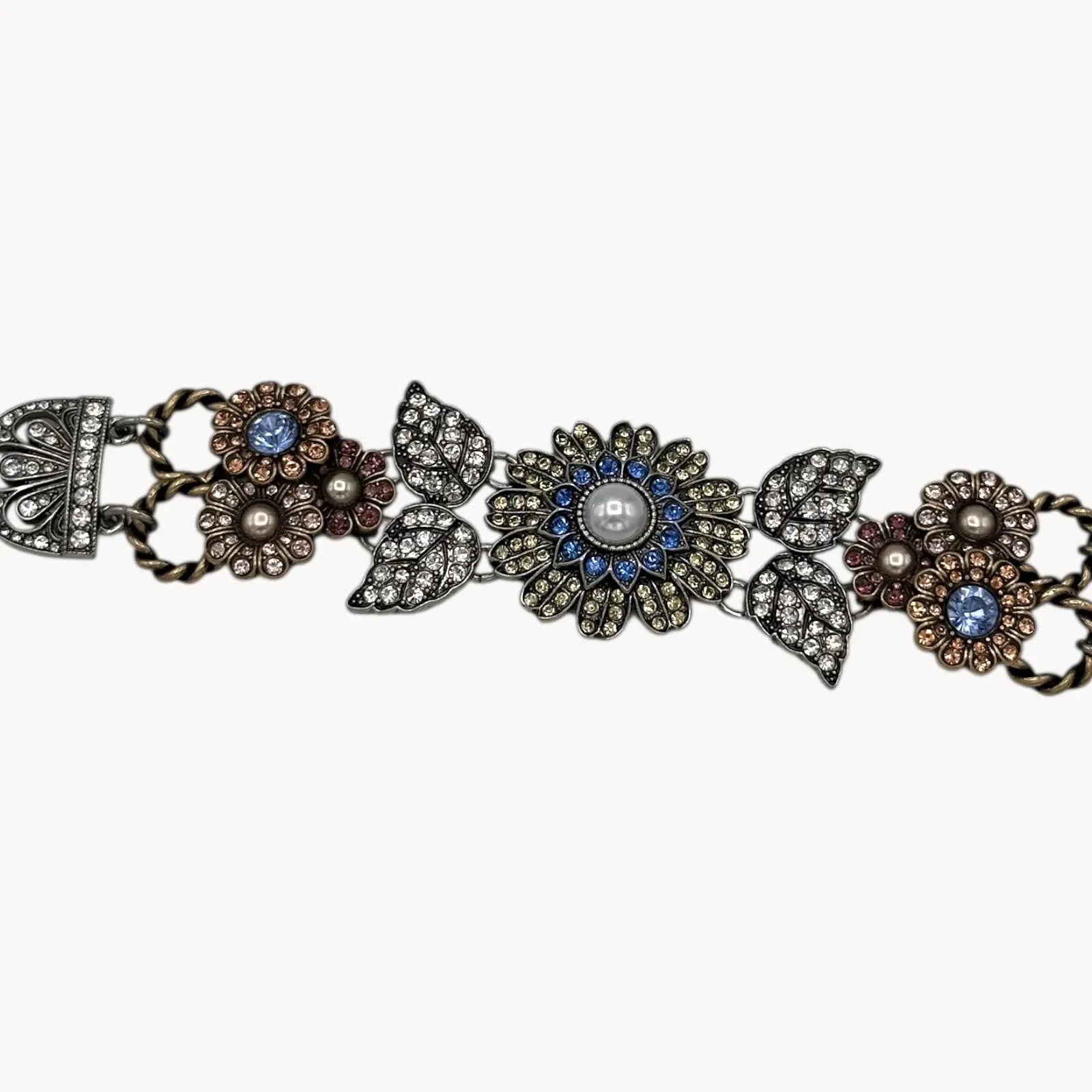 Close up of Chloe + Isabel multi-color floral rhinestone bracelet with pearls and crystal leaves on white background.