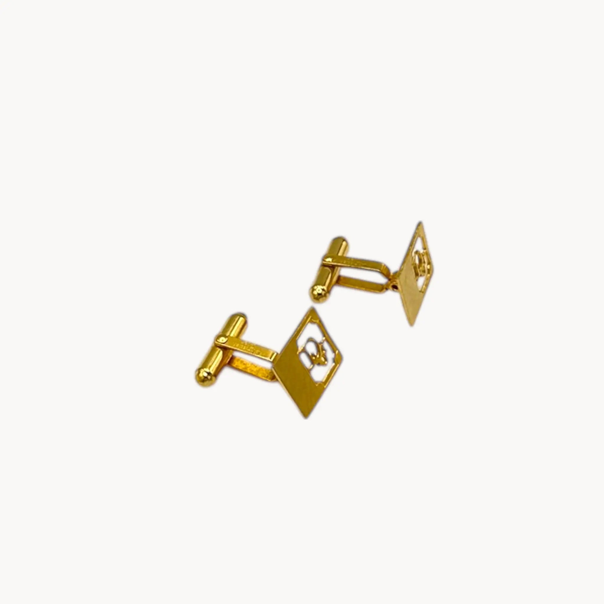 Side view of Vintage Christian Dior gold-plated square cufflinks with logo cutout design displayed on white background.