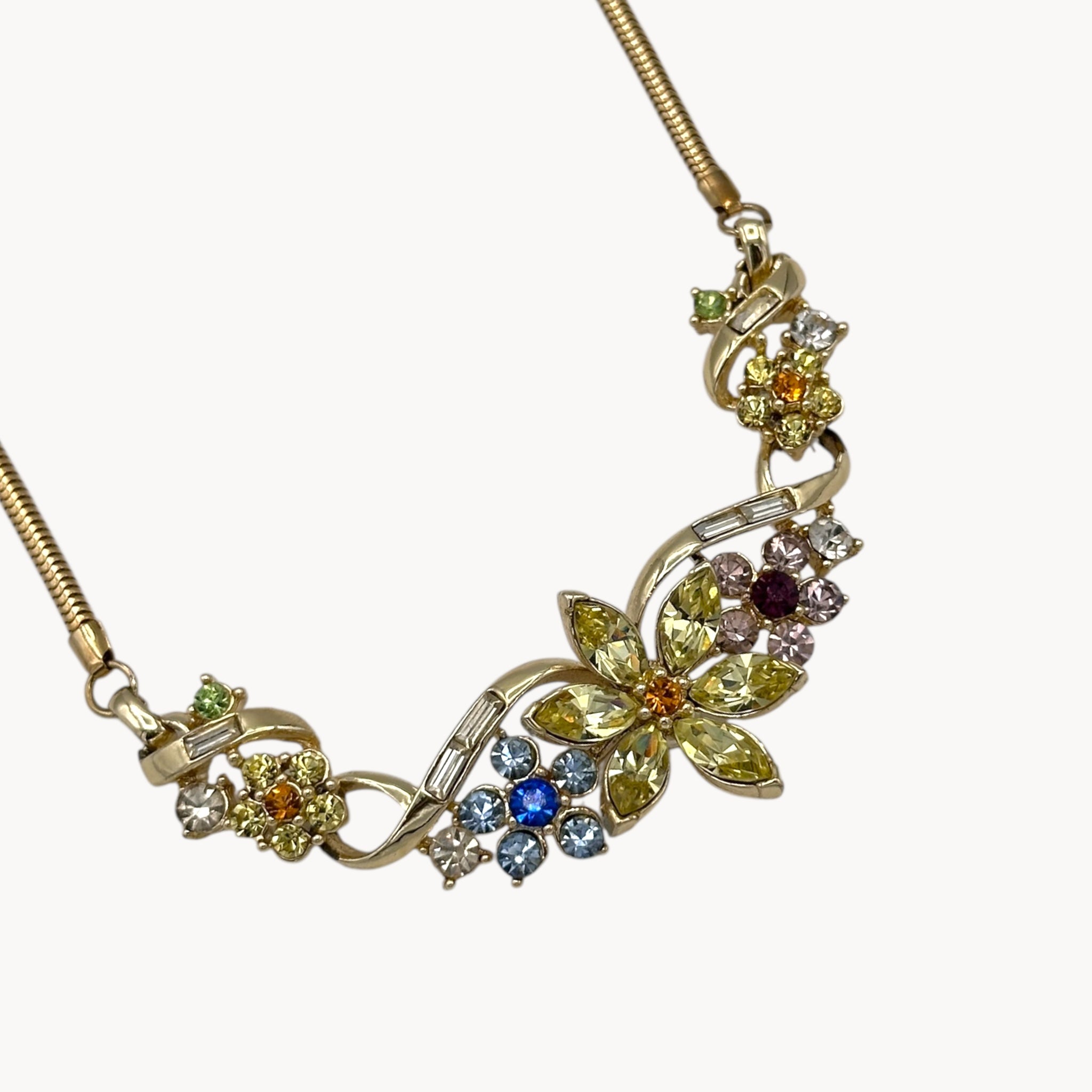 Close up view of pendant of Vintage Coro multi-color rhinestone necklace and clip-on earring set with floral design