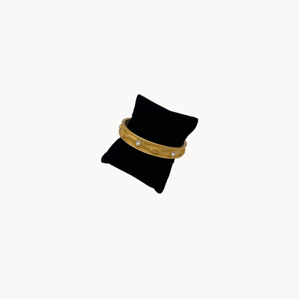 Side view of Elizabeth Taylor Love Blooms gold bangle bracelet with crystal heart and floral accents.