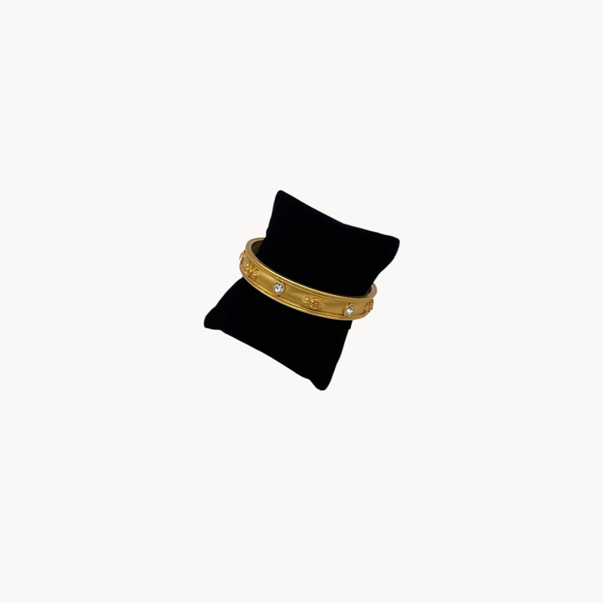 Side view of Elizabeth Taylor Love Blooms gold bangle bracelet with crystal heart and floral accents.