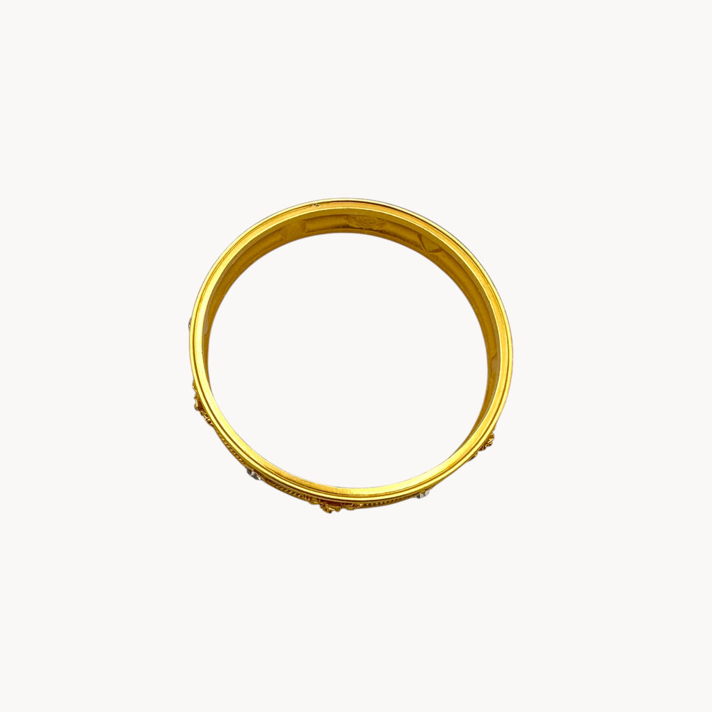Top view of Elizabeth Taylor Love Blooms gold bangle bracelet with crystal heart and floral accents.