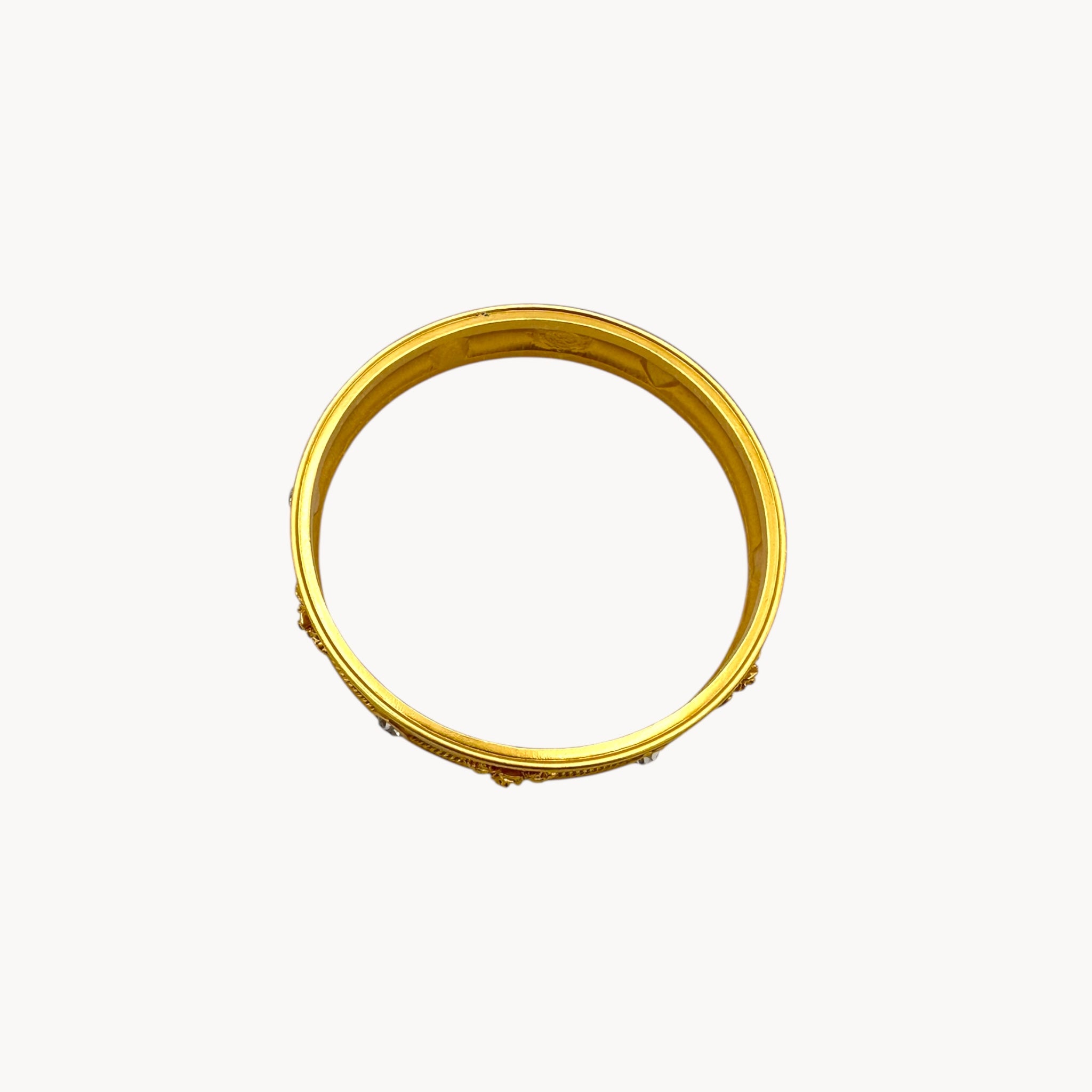 Top view of Elizabeth Taylor Love Blooms gold bangle bracelet with crystal heart and floral accents.