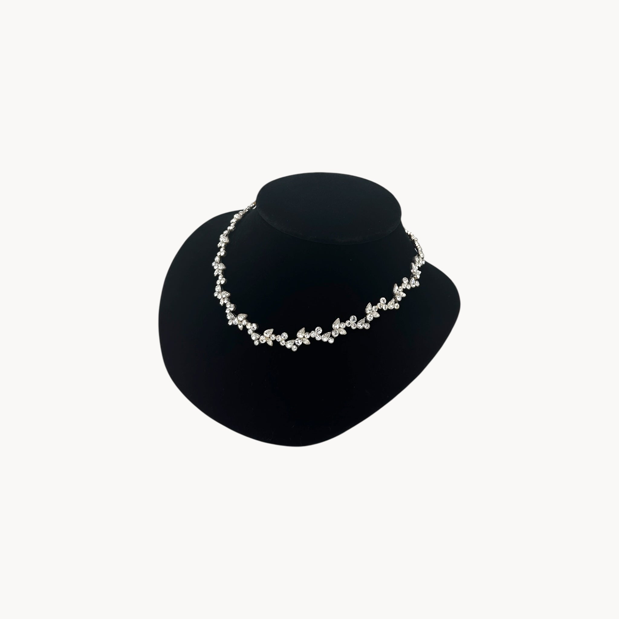 Side view of Givenchy silver-tone floral crystal rhinestone necklace, vintage bridal jewelry on black bust.