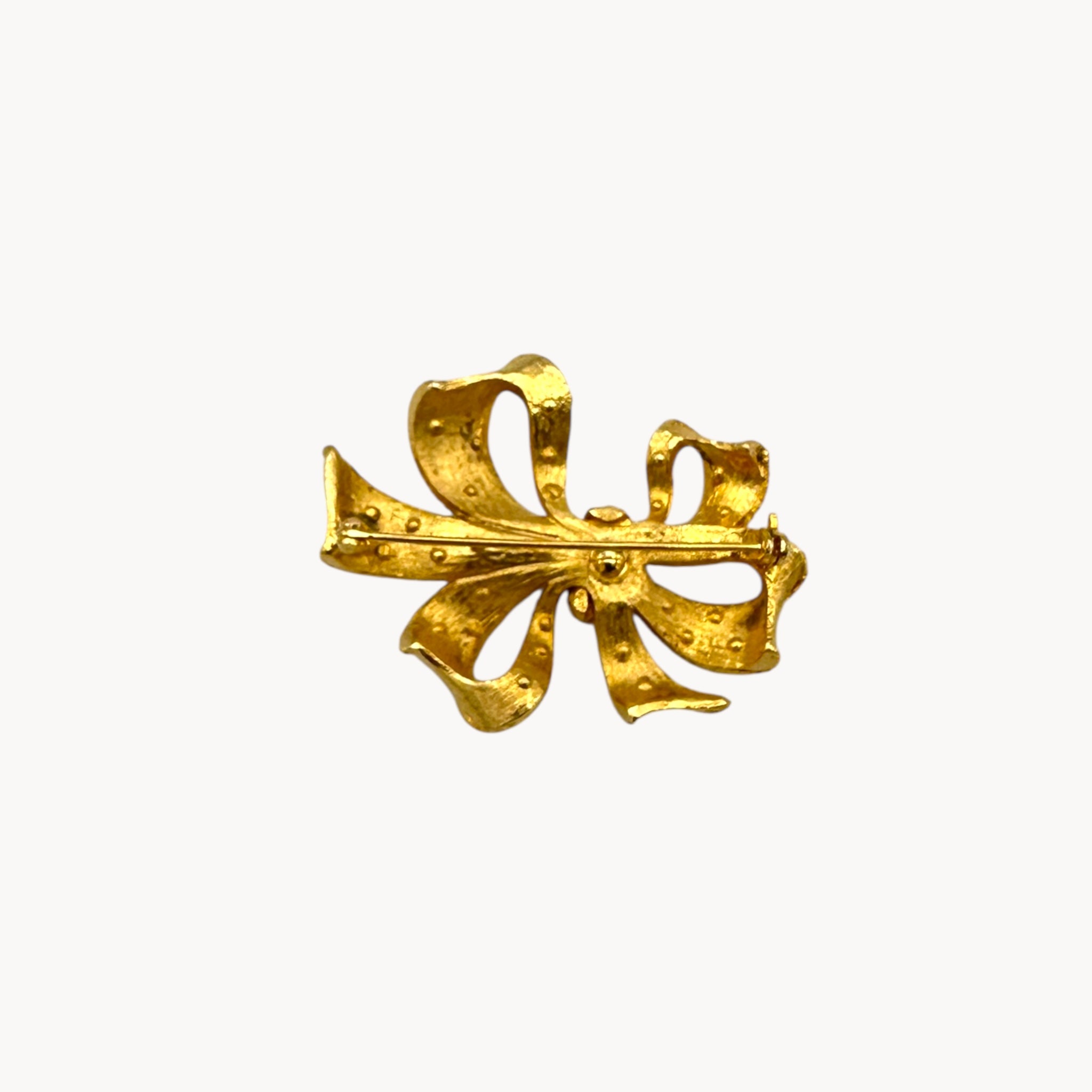 Close up of back of Vintage gold rhinestone bow brooch with ribbon design
