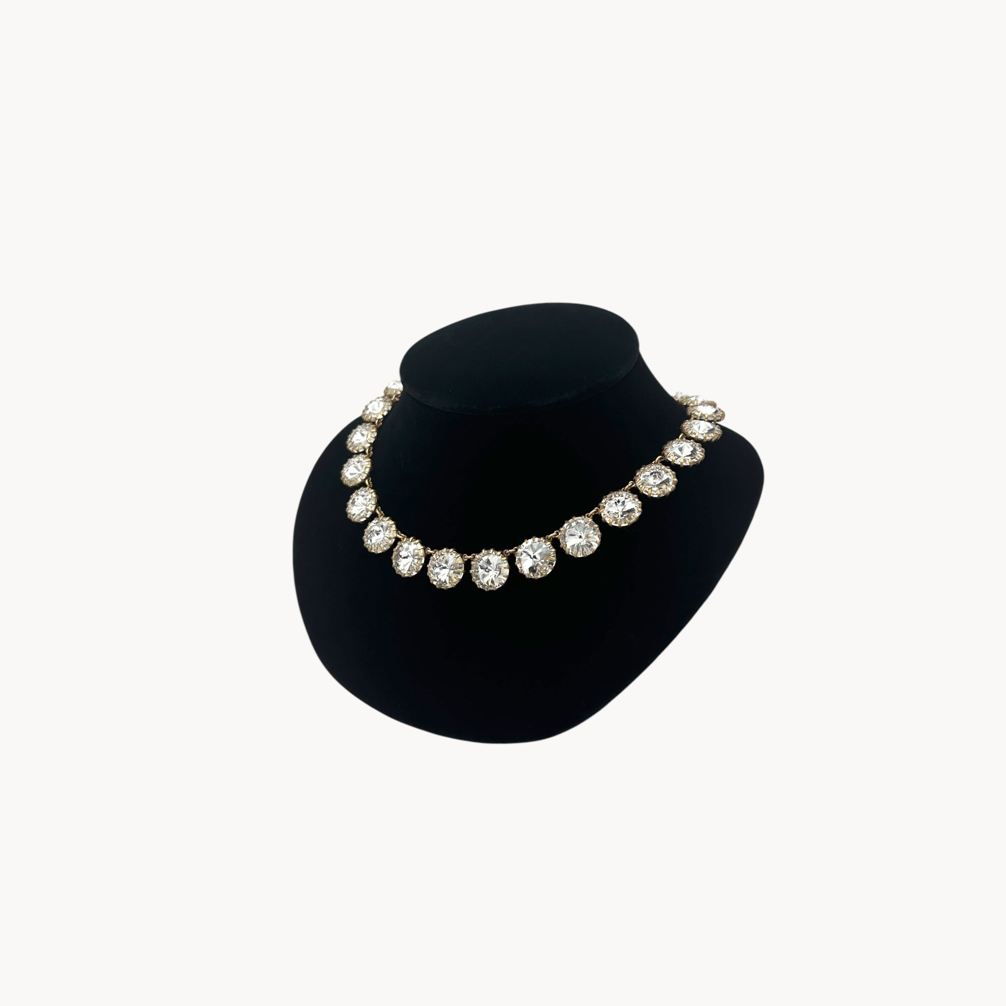 Side view of J. Crew Venus Flytrap necklace with large clear round rhinestones on black bust.