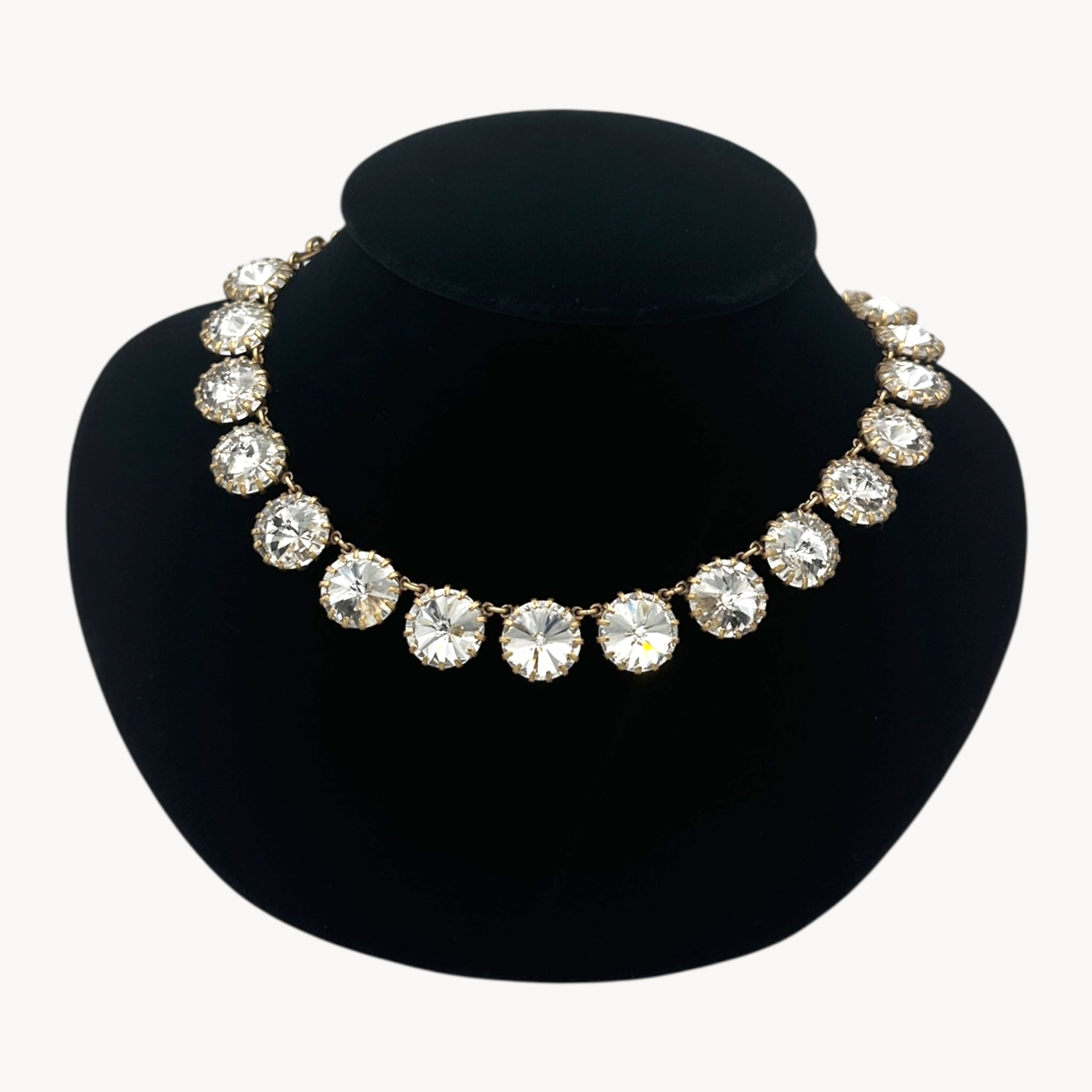 Close up view of J. Crew Venus Flytrap necklace with large clear round rhinestones on black bust.