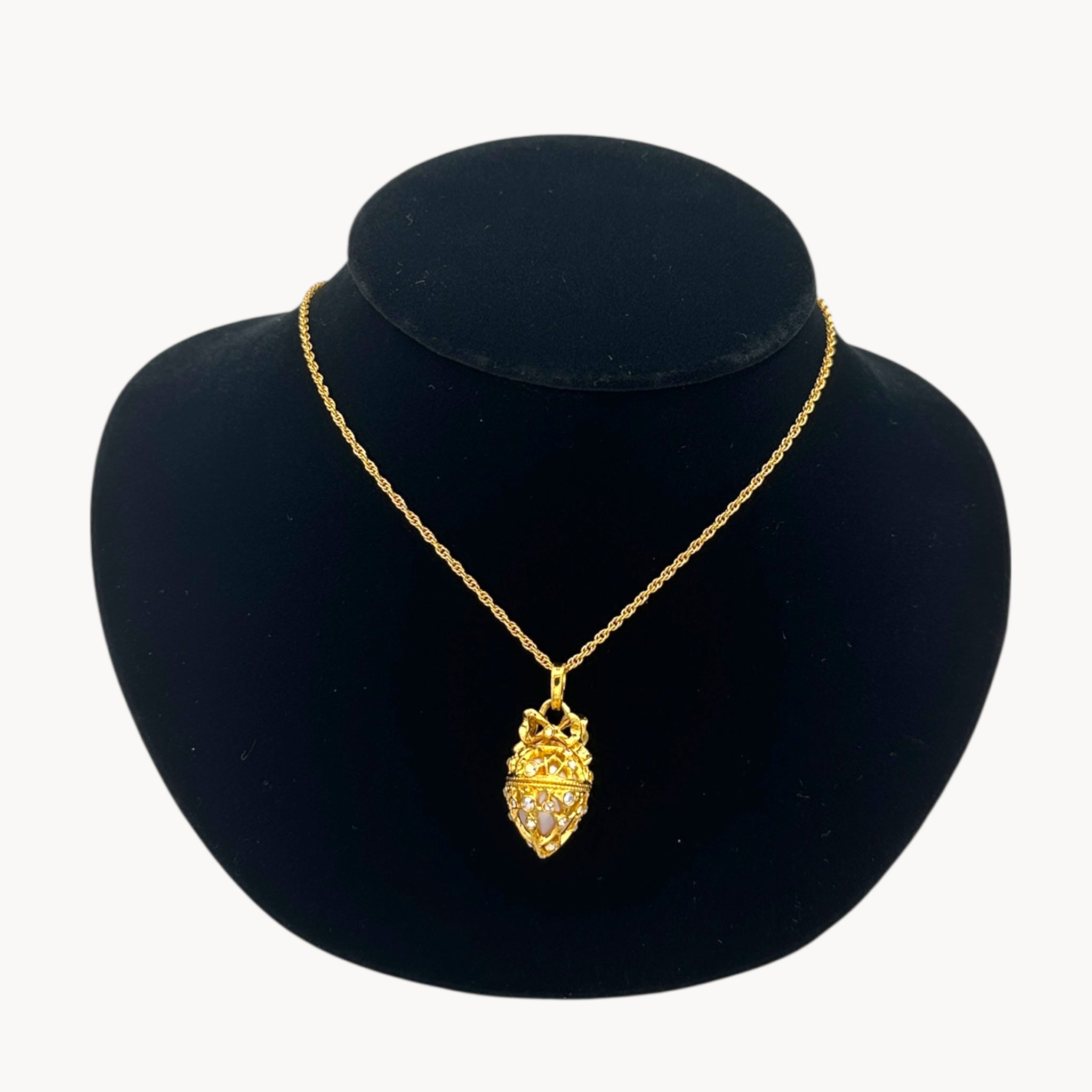 Close up view of Joan Rivers gold egg locket necklace on long chain