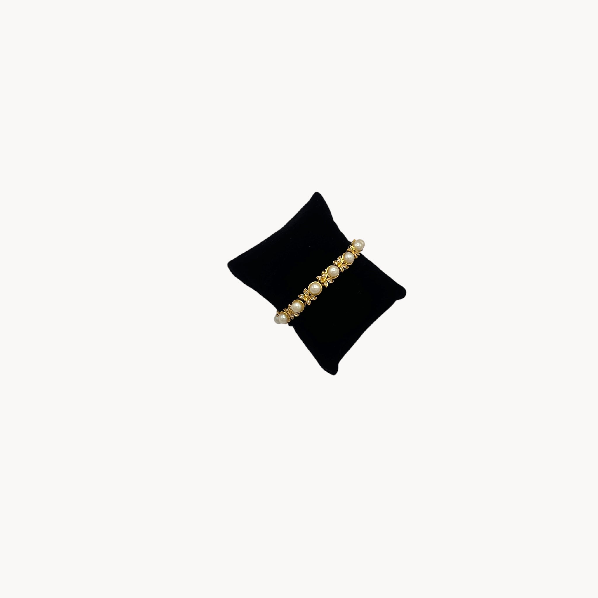 Left side view of Joan Rivers gold bracelet with pearls and rhinestones.