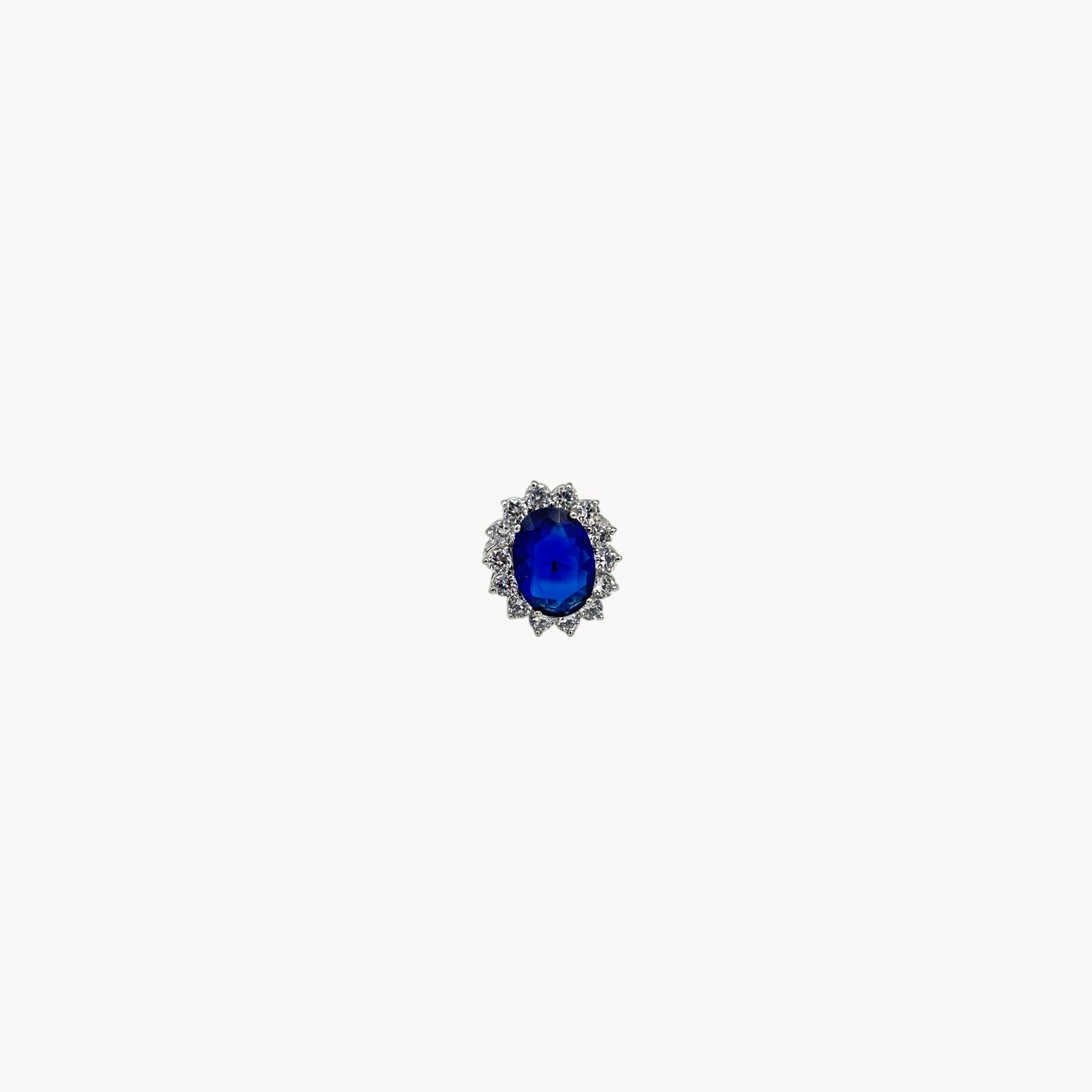 Kenneth Jay Lane blue oval crystal cocktail ring inspired by Princess Diana’s sapphire engagement ring on white background.
