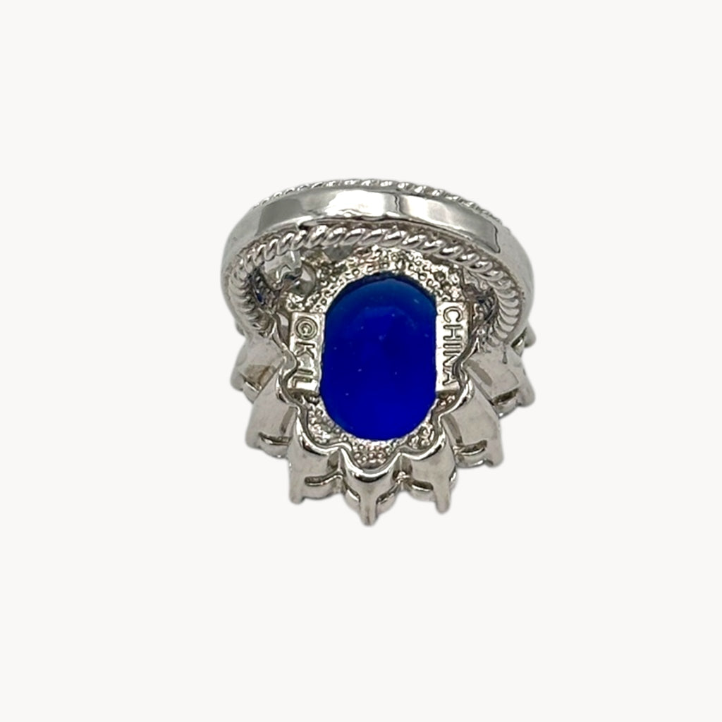 Inside view of Kenneth Jay Lane blue oval crystal cocktail ring inspired by Princess Diana’s sapphire engagement ring on white background.
