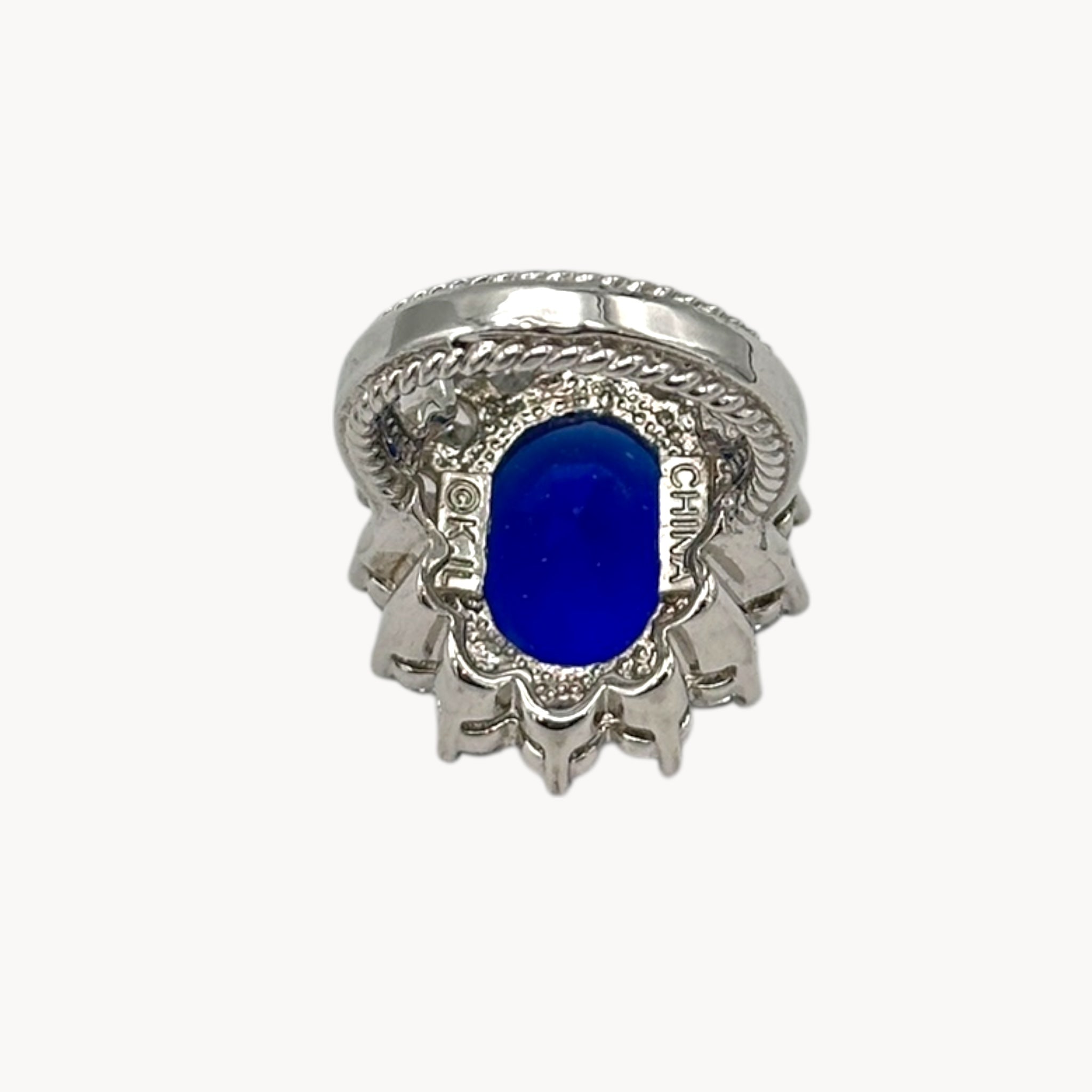 Inside view of Kenneth Jay Lane blue oval crystal cocktail ring inspired by Princess Diana’s sapphire engagement ring on white background.