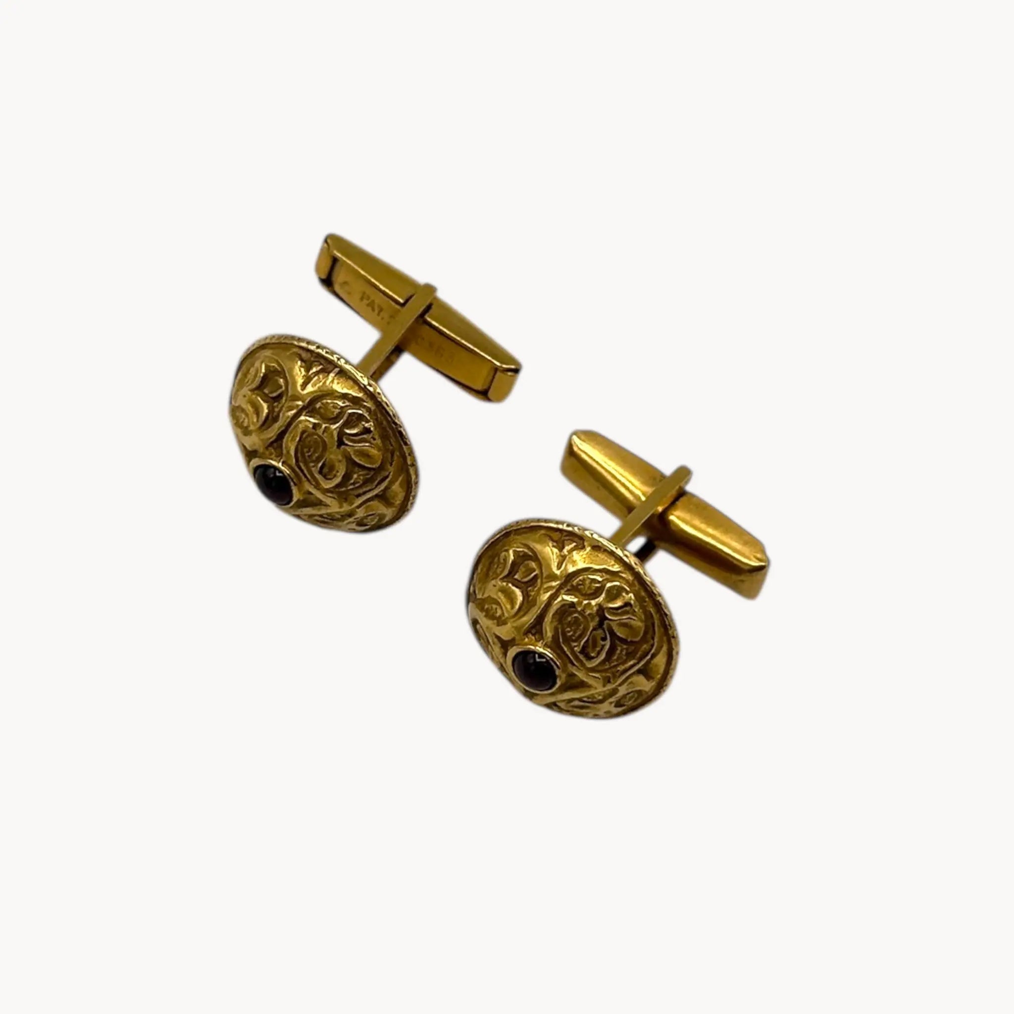 Side view of Vintage MMA gold embossed cufflinks with cabochon centers displayed on white background.