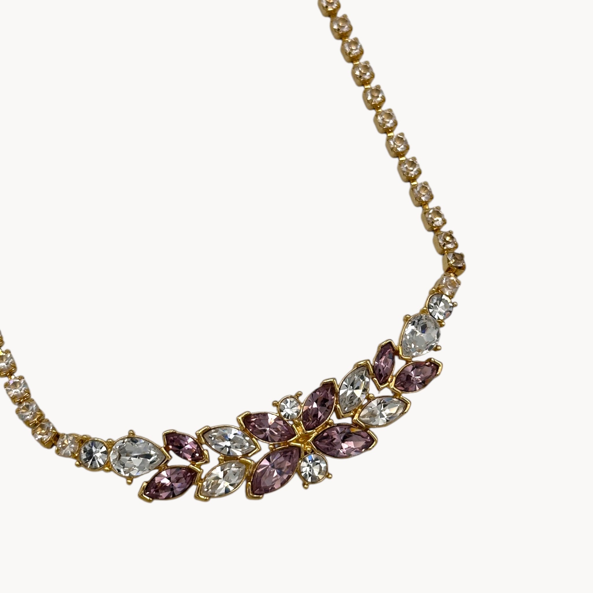 Close up of pendant of Monet vintage pink and clear rhinestone floral necklace on gold-tone chain, romantic bridal jewelry.