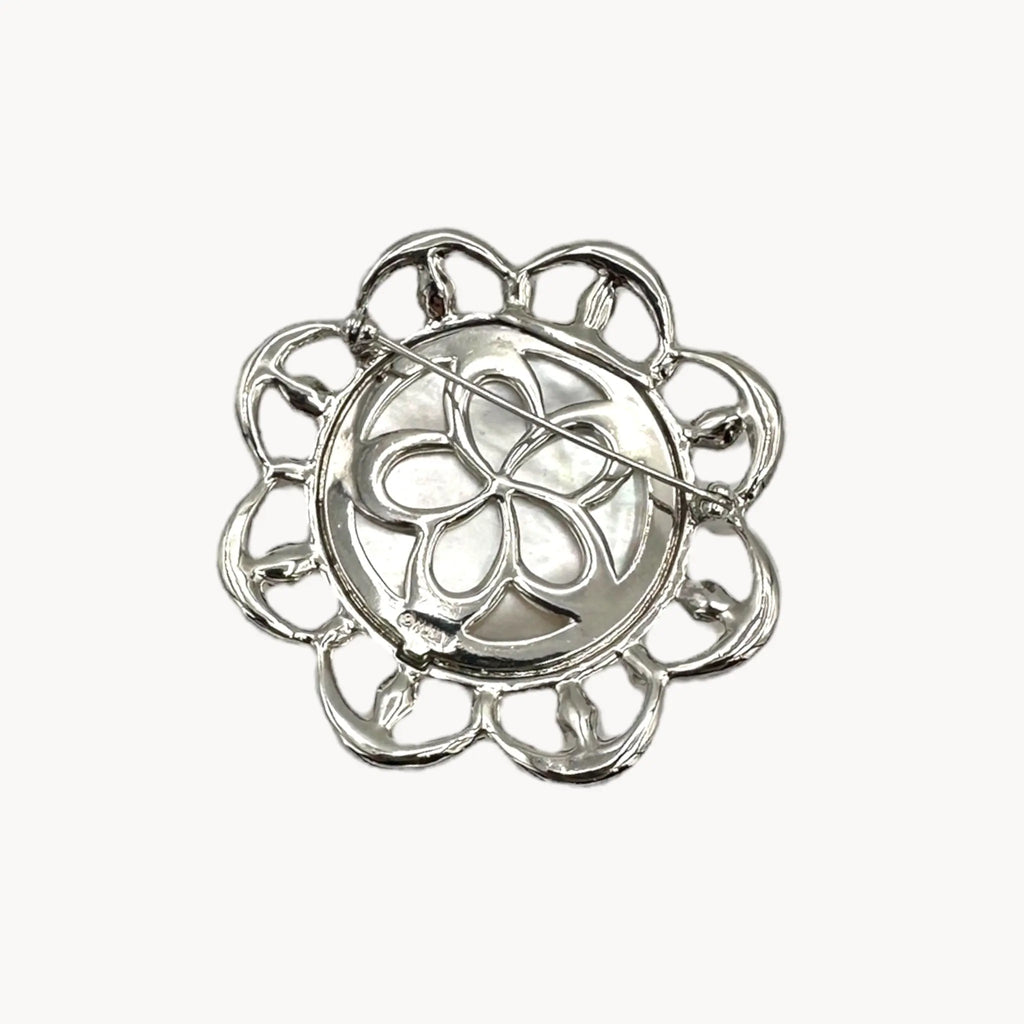 Back view of Monet vintage silver tone brooch with rhinestones and faux pearls in floral design, elegant bridal jewelry piece on white background.