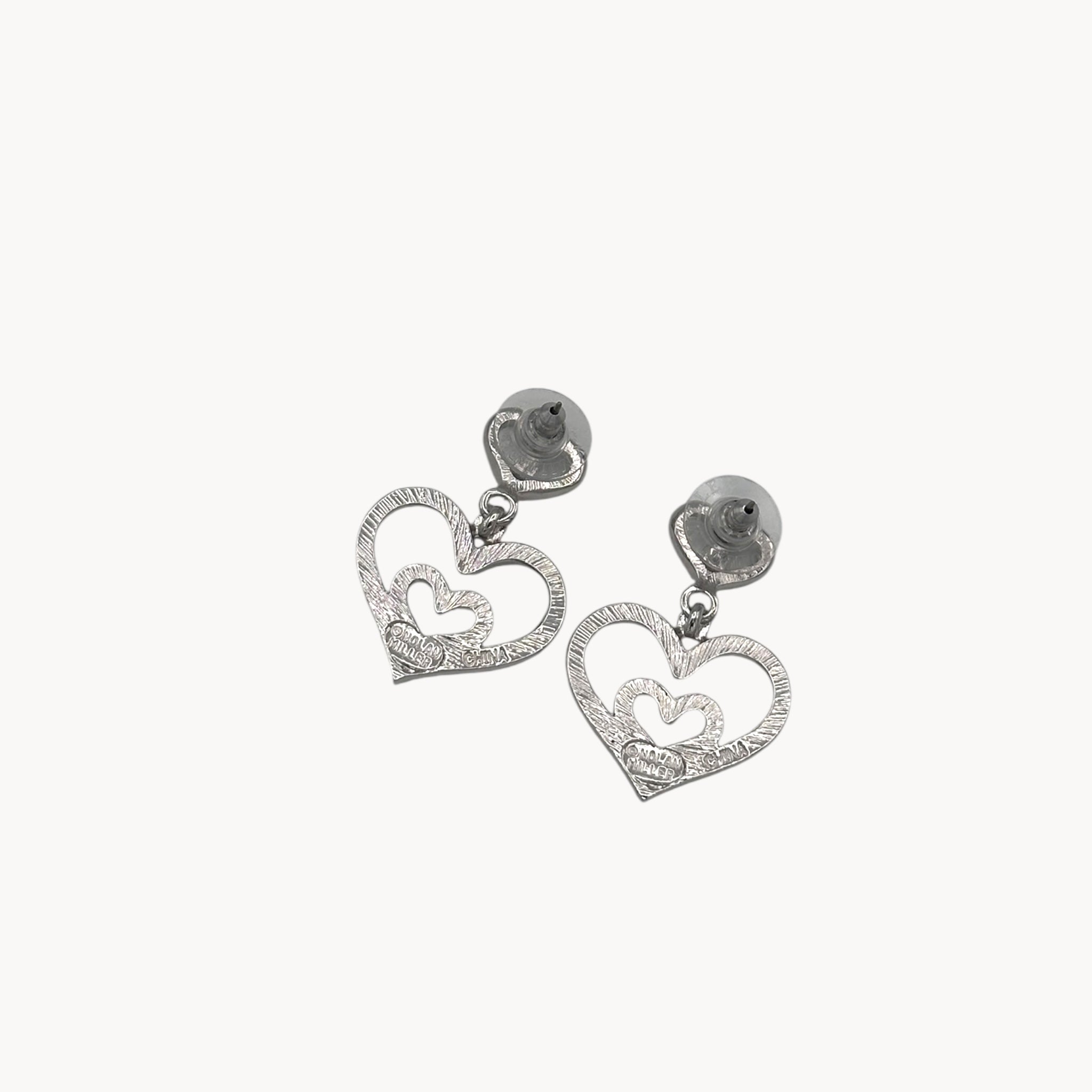 Back view of Vintage Nolan Miller rhinestone heart dangle pierced earrings with double open-heart design.
