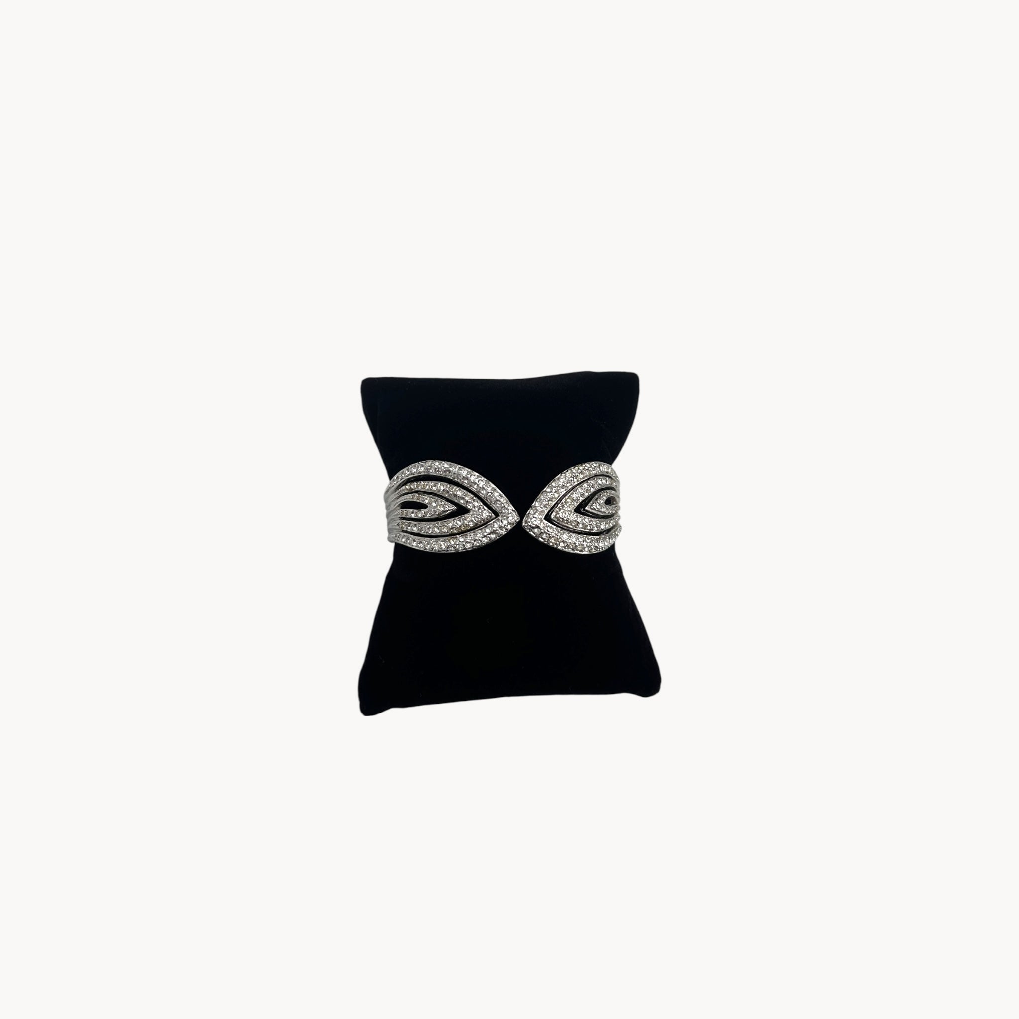 Front view Nolan Miller silver rhinestone hinged bangle bracelet with overlapping design.