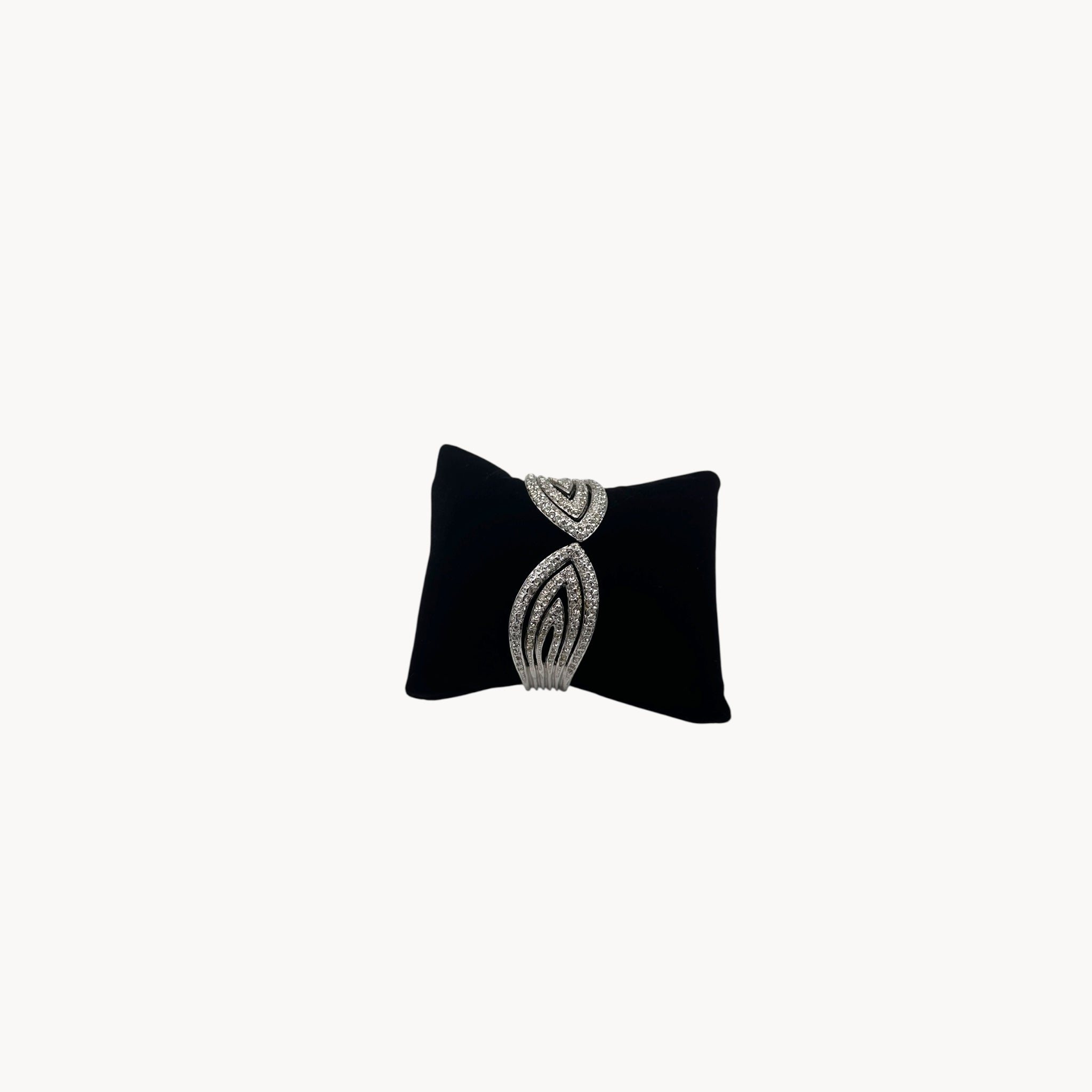 Side view Nolan Miller silver rhinestone hinged bangle bracelet with overlapping design.