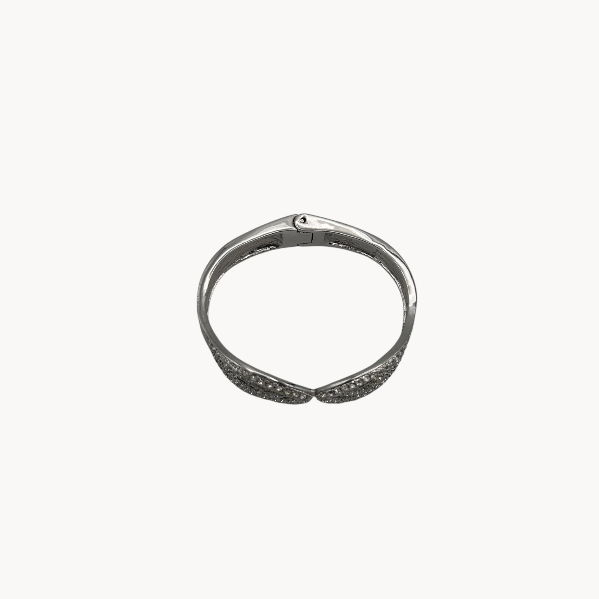 Top view of Nolan Miller silver rhinestone hinged bangle bracelet with overlapping design.