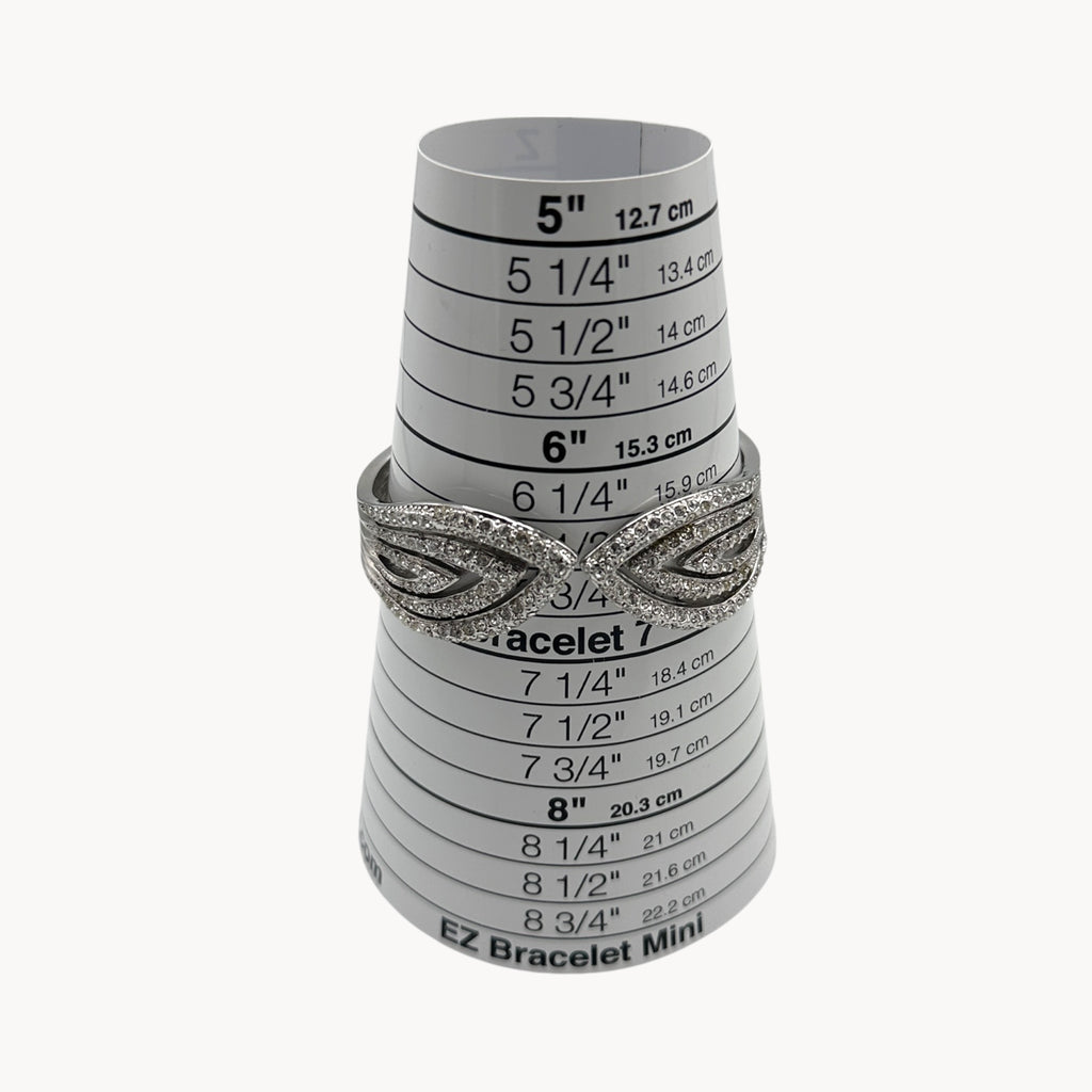 Size view of Nolan Miller silver rhinestone hinged bangle bracelet with overlapping design.