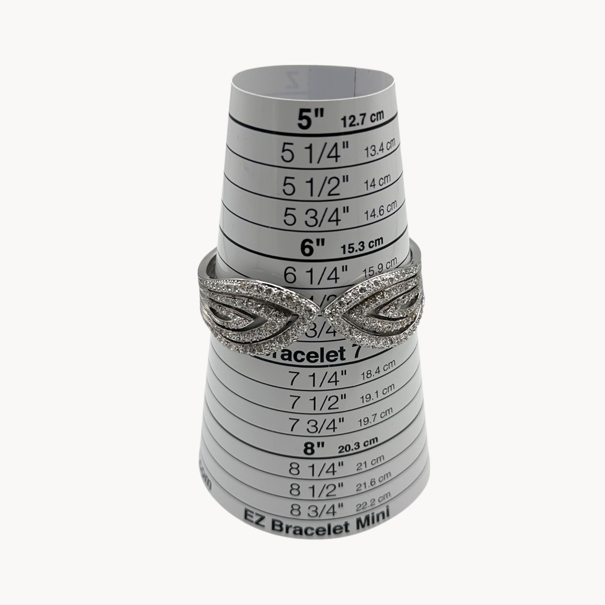 Size view of Nolan Miller silver rhinestone hinged bangle bracelet with overlapping design.
