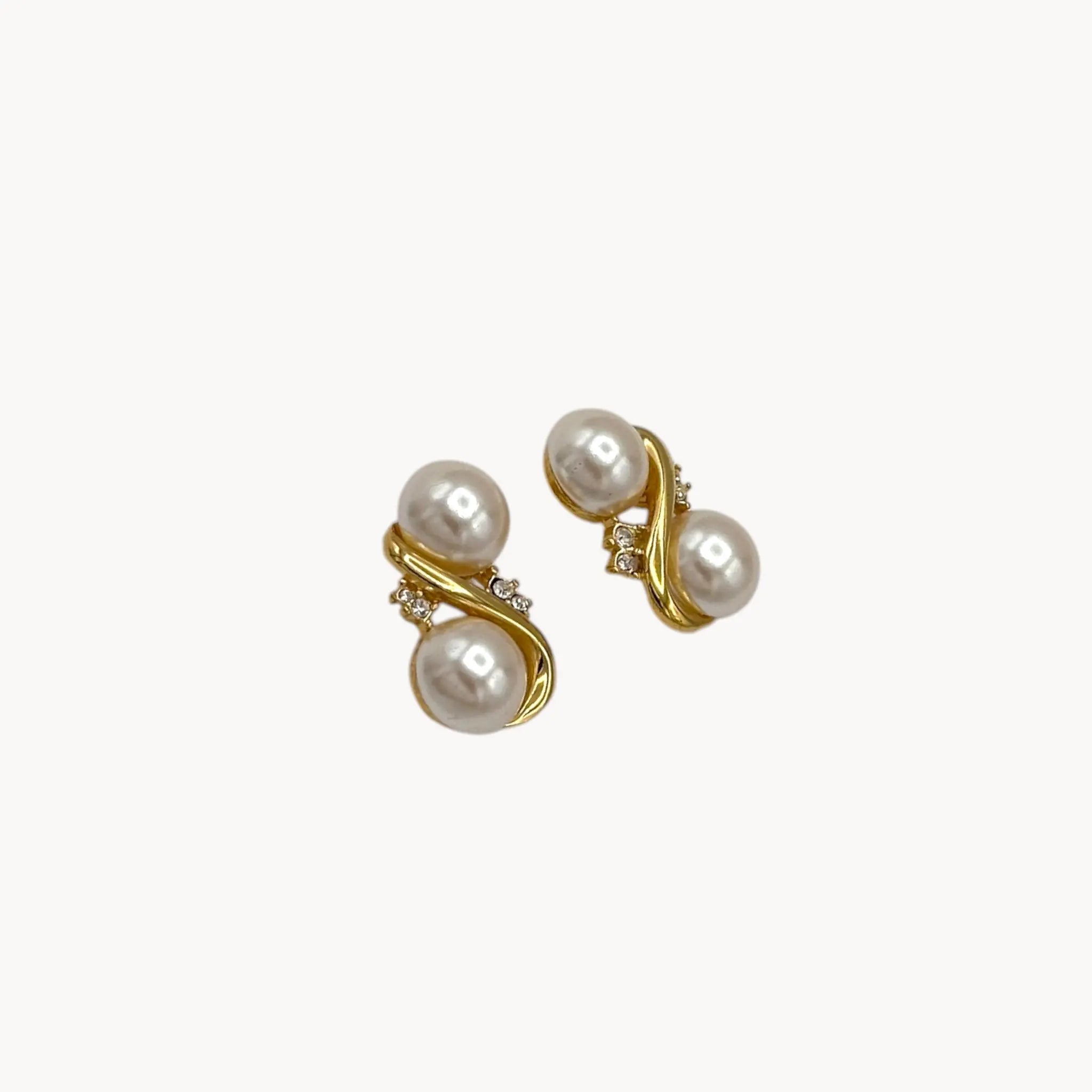 Side view of Richelieu vintage gold tone pierced earrings with double faux pearls and rhinestone accents, elegant 1980s bridal jewelry shown on white background.