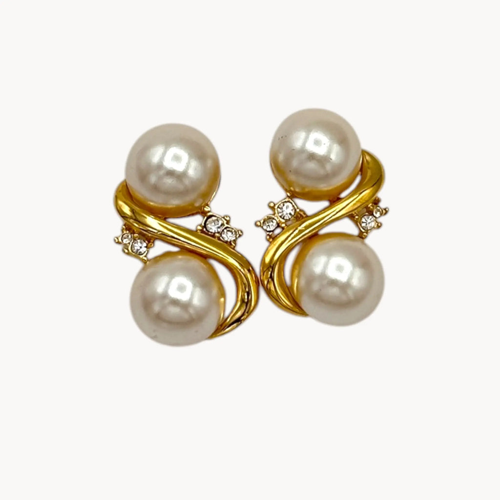 Close up view of Richelieu vintage gold tone pierced earrings with double faux pearls and rhinestone accents, elegant 1980s bridal jewelry shown on white background.