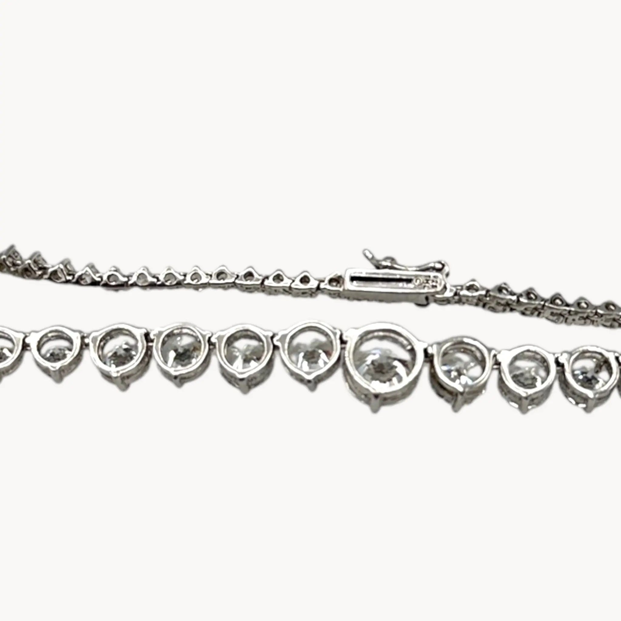 Back view of Sterling silver rhodium-plated graduated tennis necklace with round-cut stones on white background.