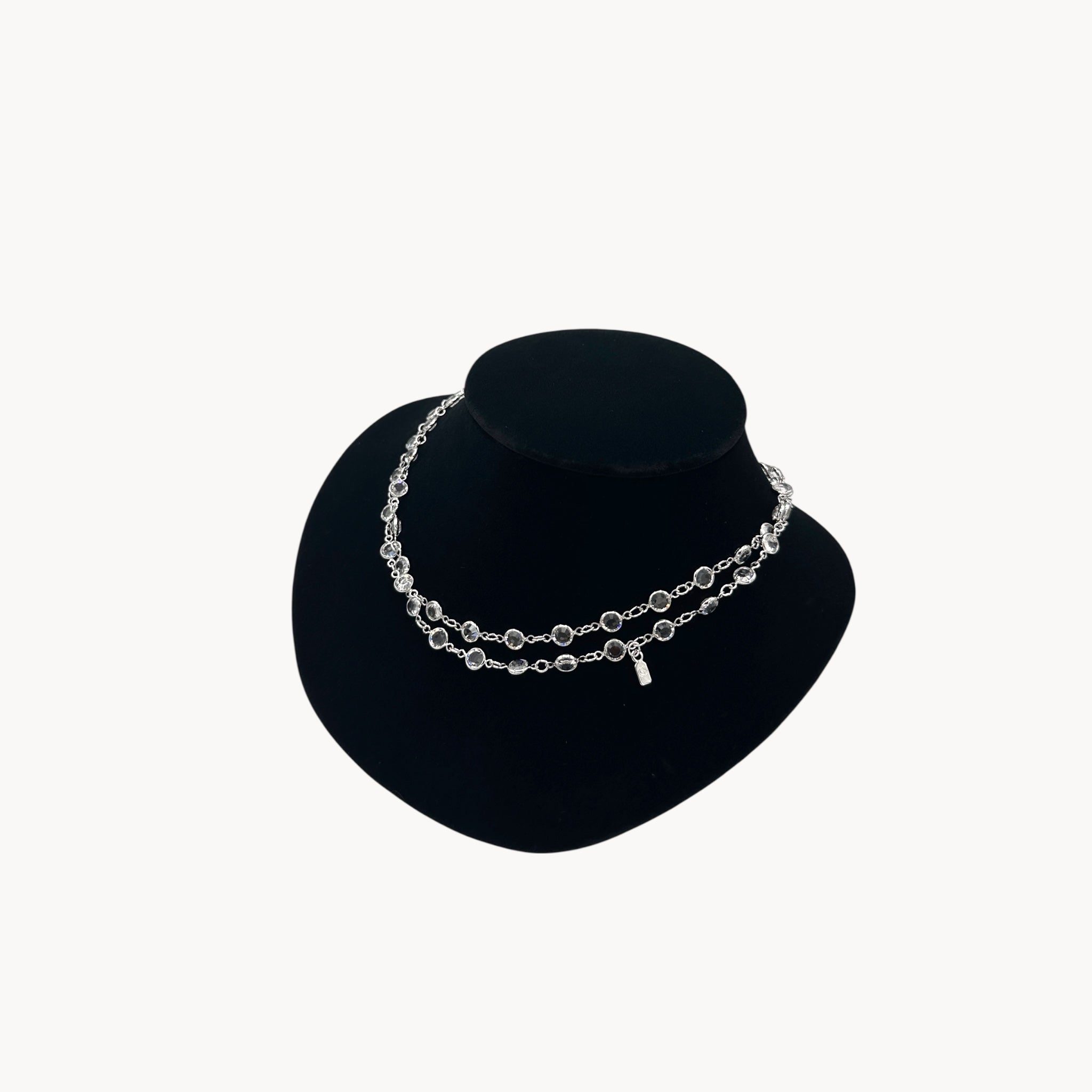 Side view of Swarovski faceted clear crystal bezel set long necklace.
