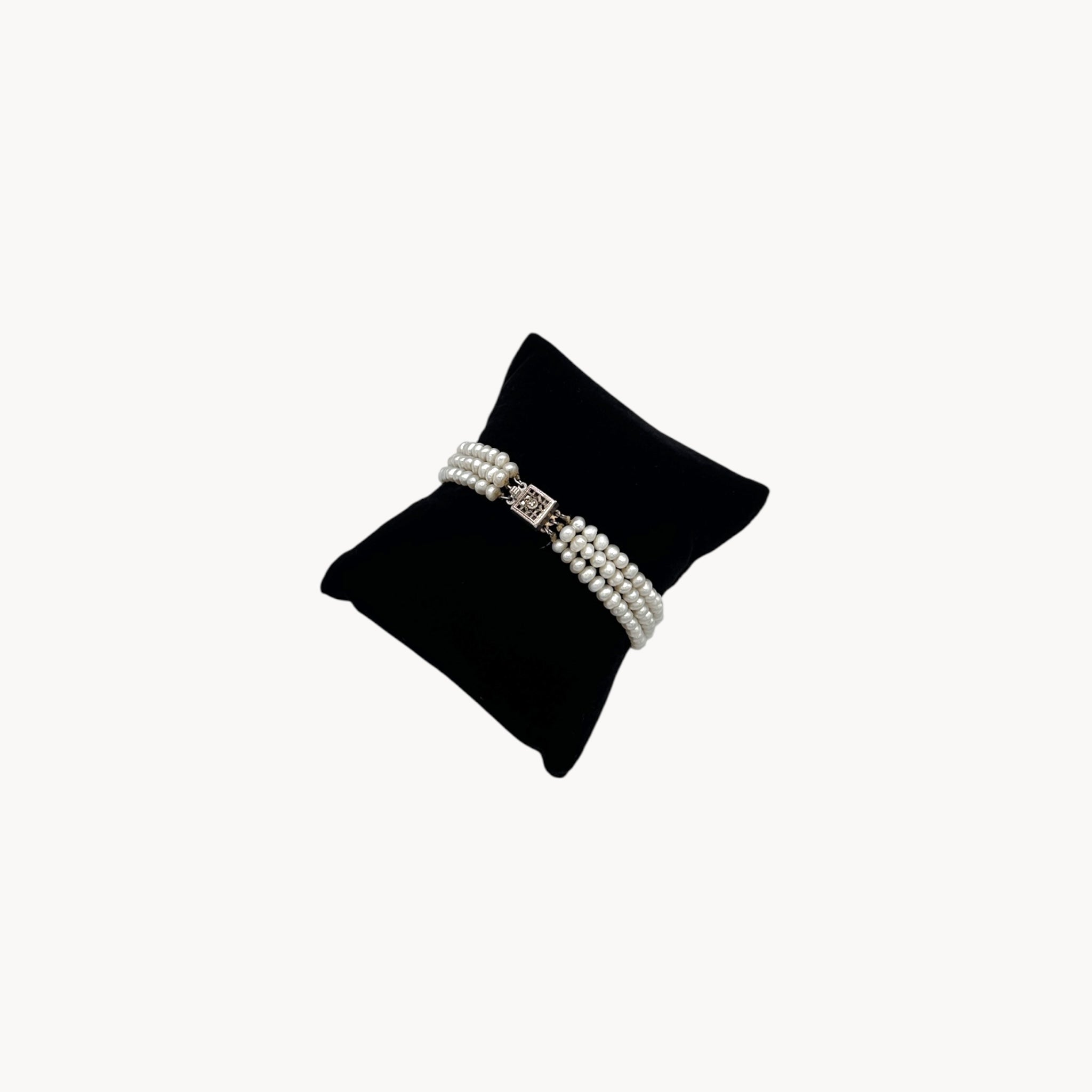 Side view of Three row pearl bracelet with silver-tone Art Deco style clasp.