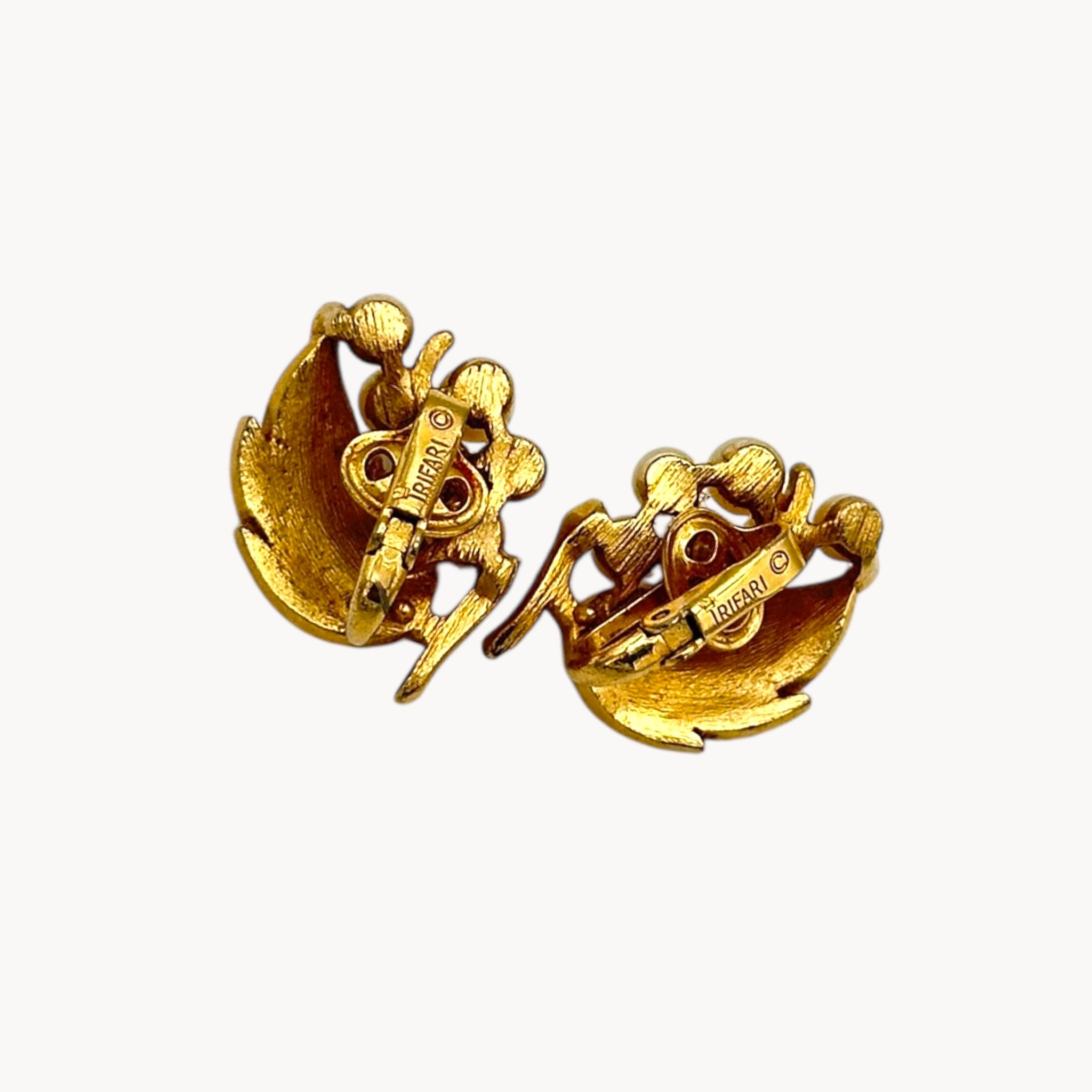 Back view of Vintage Trifari gold leaf clip-on earrings with faux pearl clusters, mid-century jewelry on white back background.
