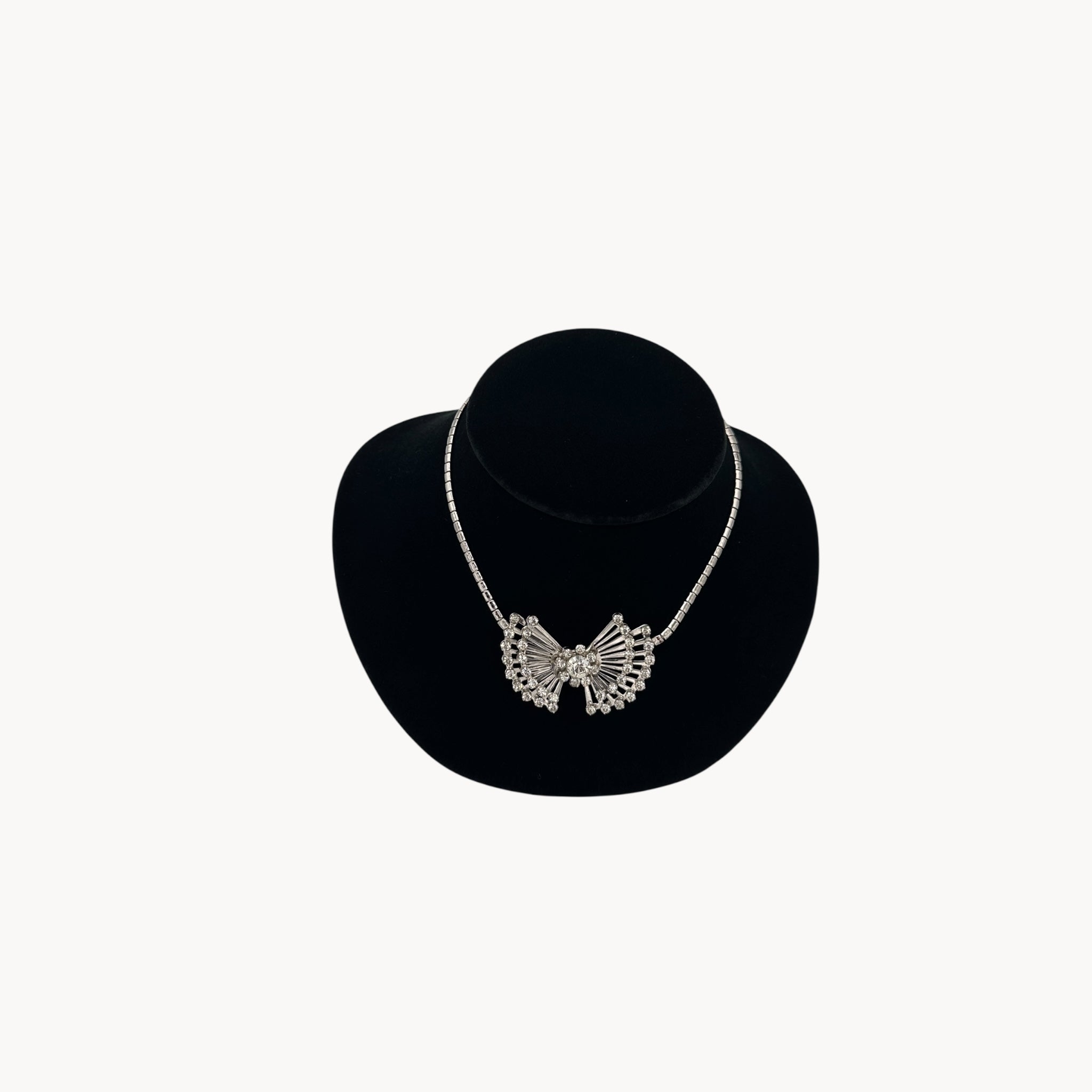 Vintage 1950s silver plated rhinestone necklace with statement bow design, mid-century bridal jewelry.