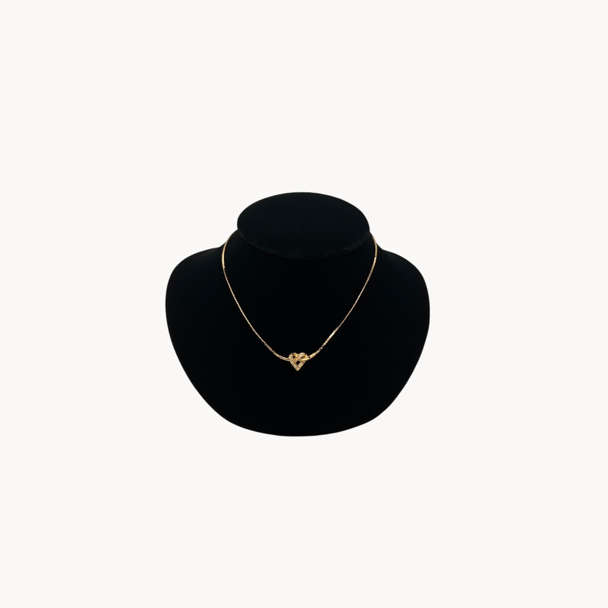 Vintage Christian Dior gold heart pendant necklace with rhinestone detail.