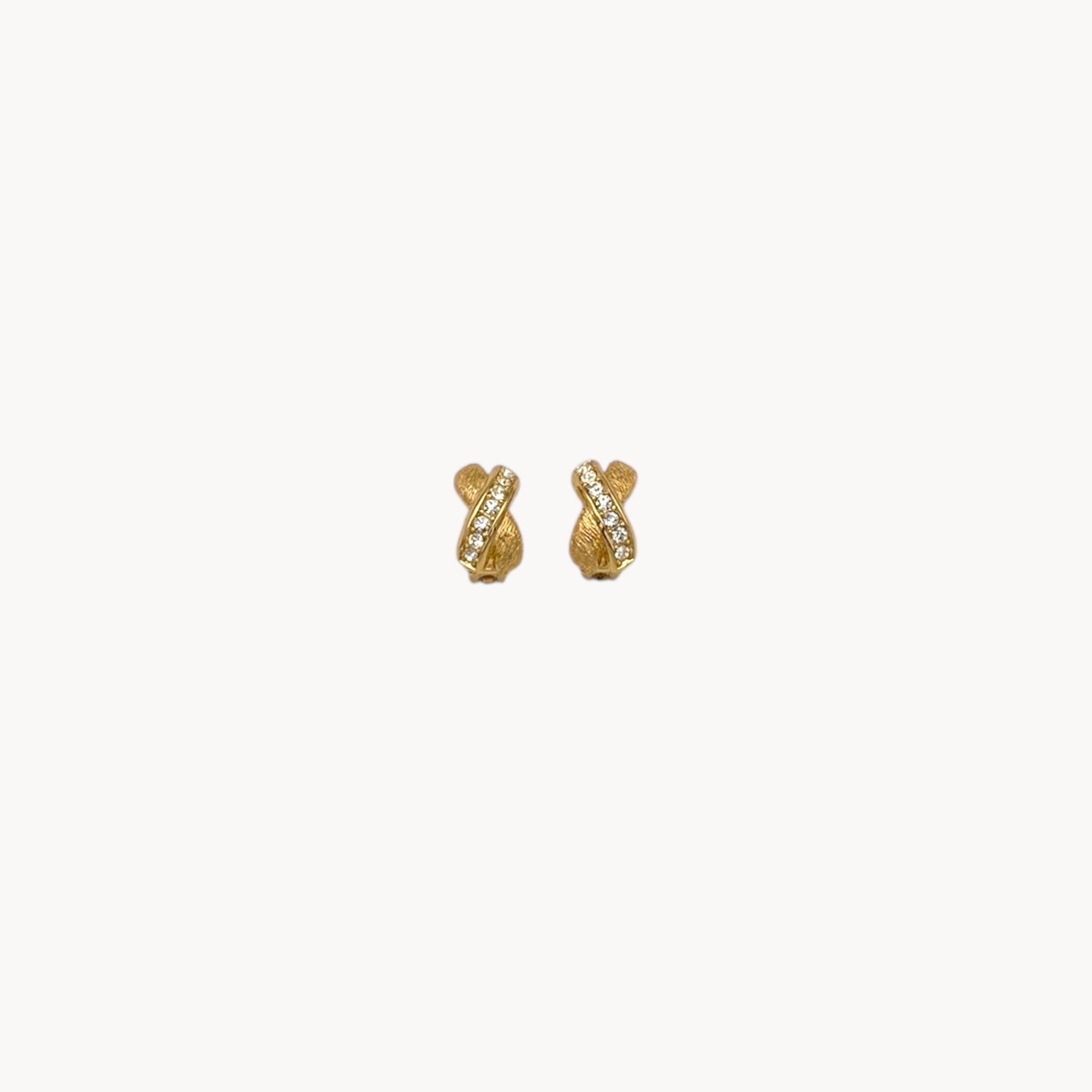 Vintage Christian Dior petite gold-tone clip-on earrings with rhinestone ribbon detail.