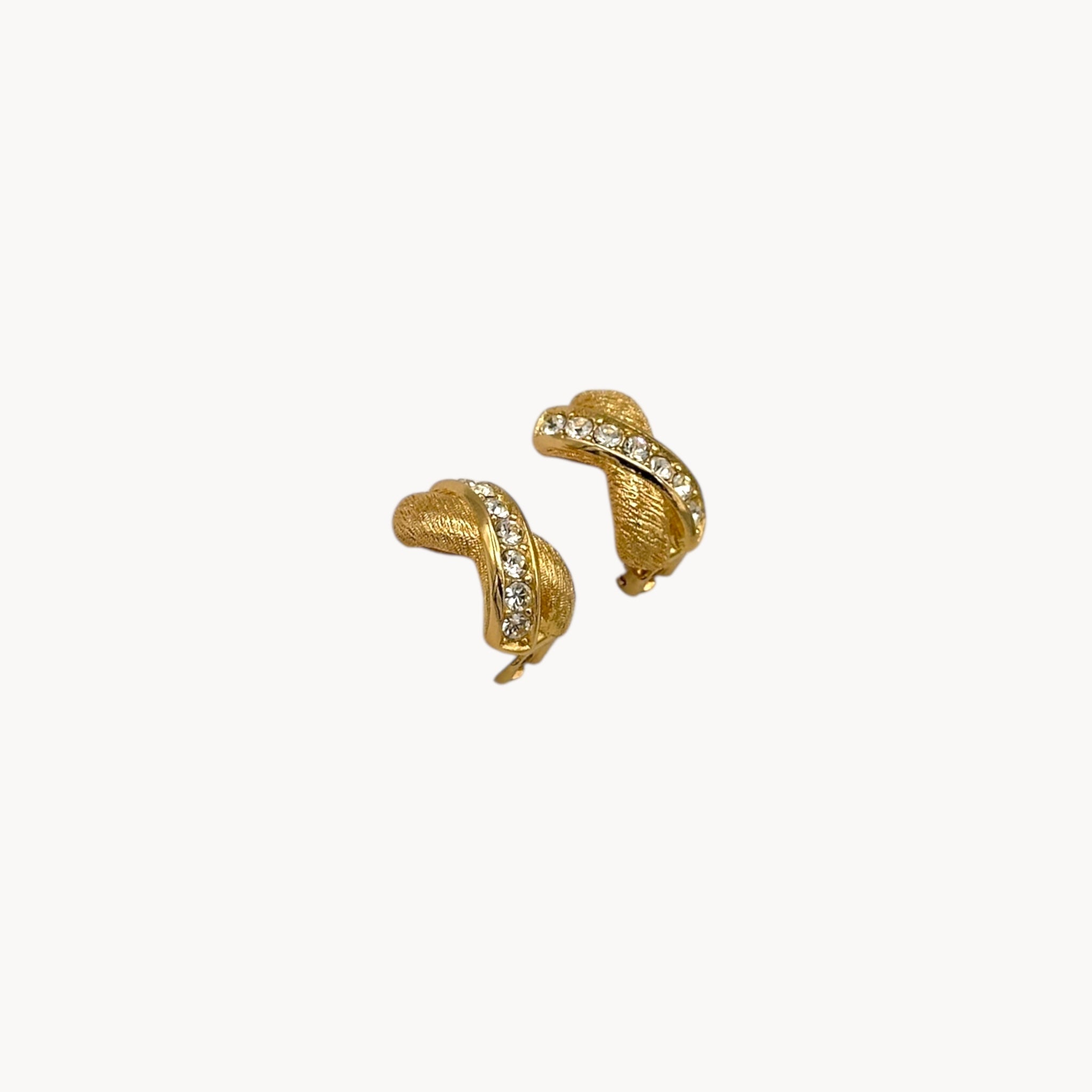 Side view of Vintage Christian Dior petite gold-tone clip-on earrings with rhinestone ribbon detail.