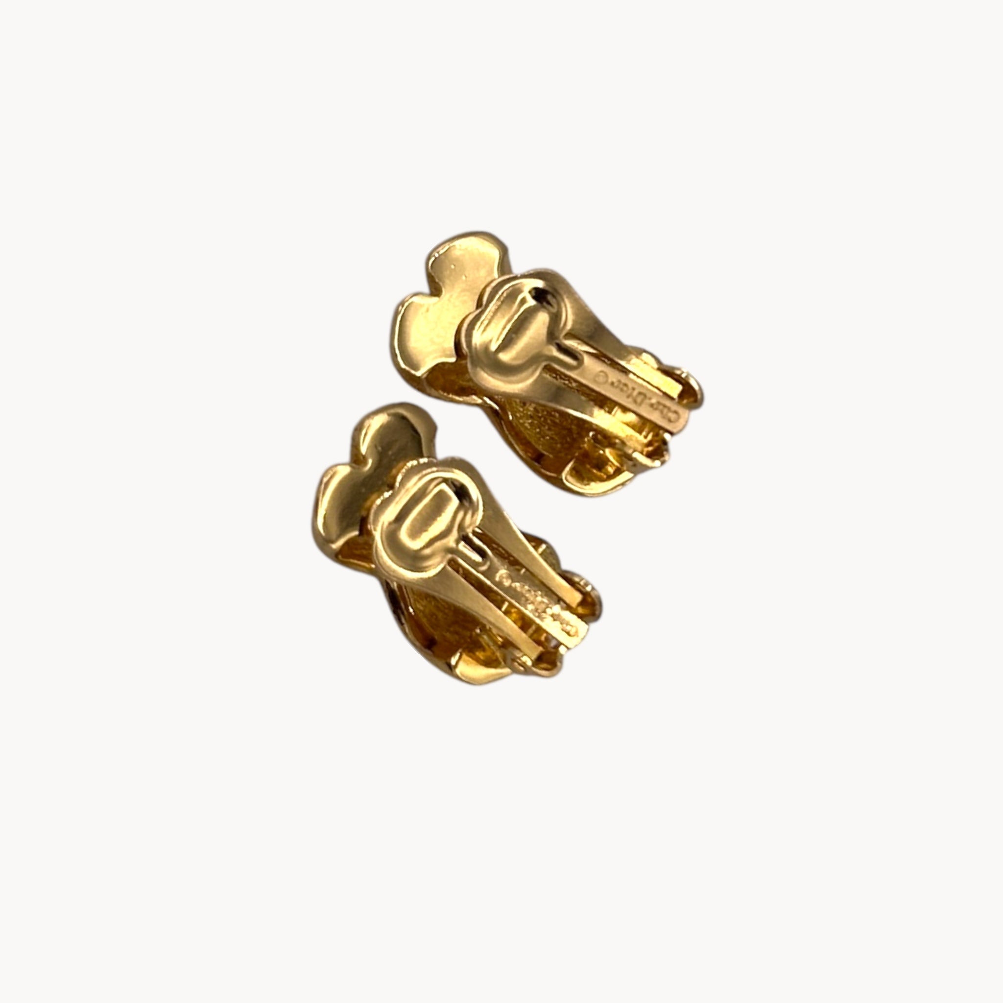Close up back view of Vintage Christian Dior petite gold-tone clip-on earrings with rhinestone ribbon detail.