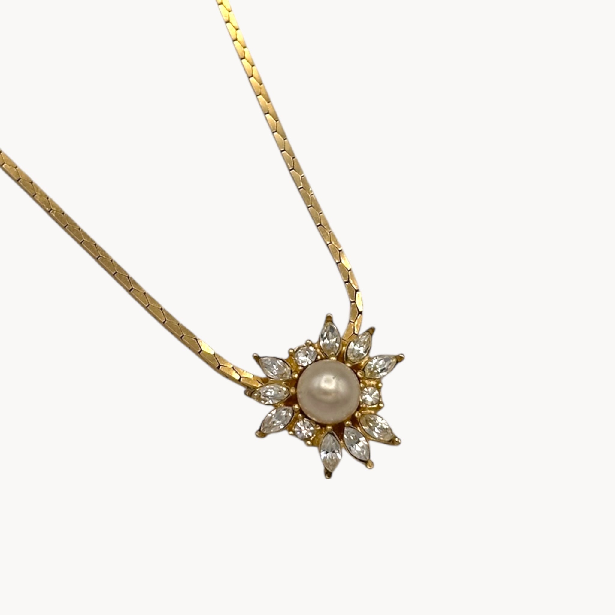 Pendant view Vintage Christian Dior necklace with gold-tone chain and starburst pendant featuring pearl center and crystal accents, 1980s bridal jewelry.