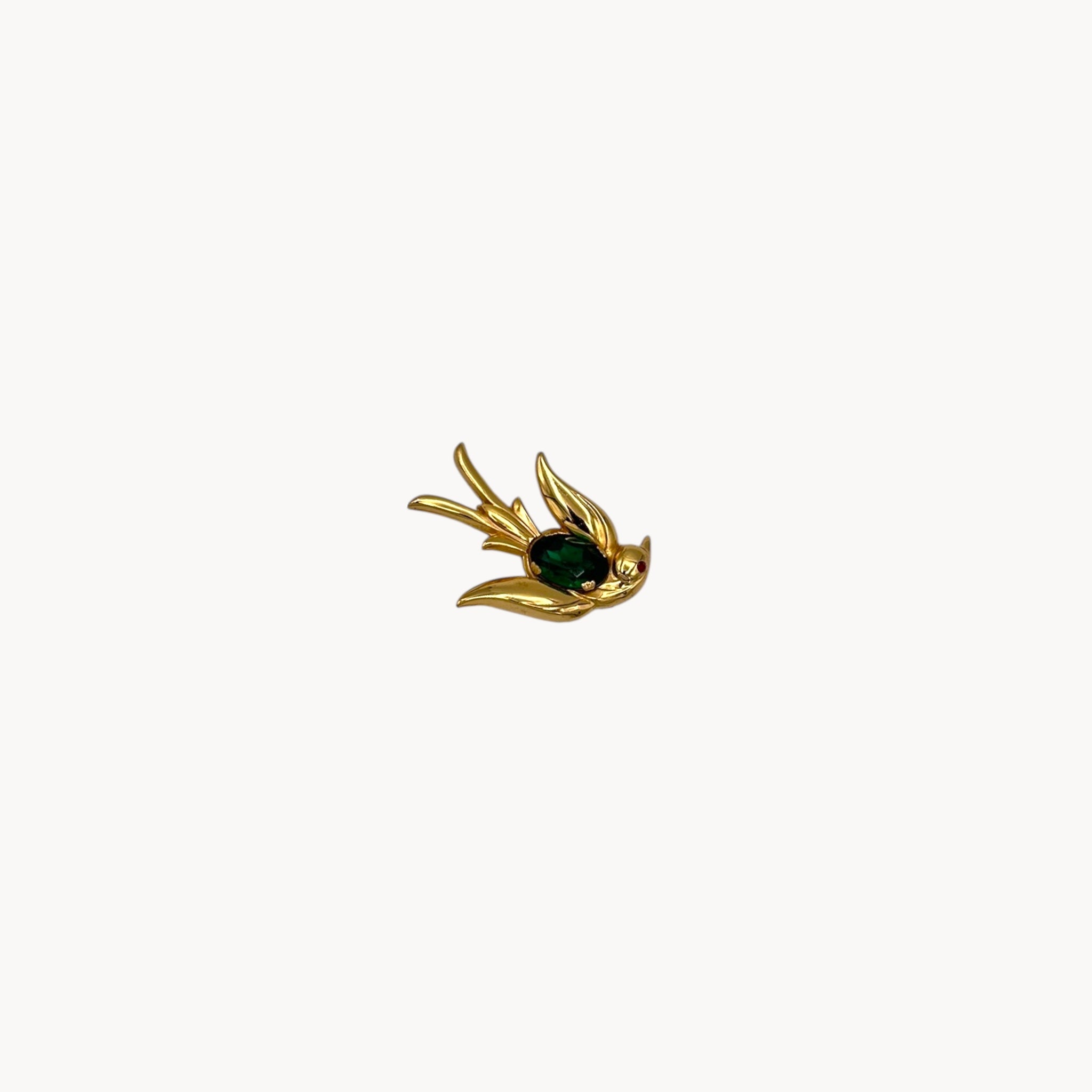 Vintage Coro gold-tone bird brooch with green glass stone body and red eye accent, 1950s whimsical bridal accessory.