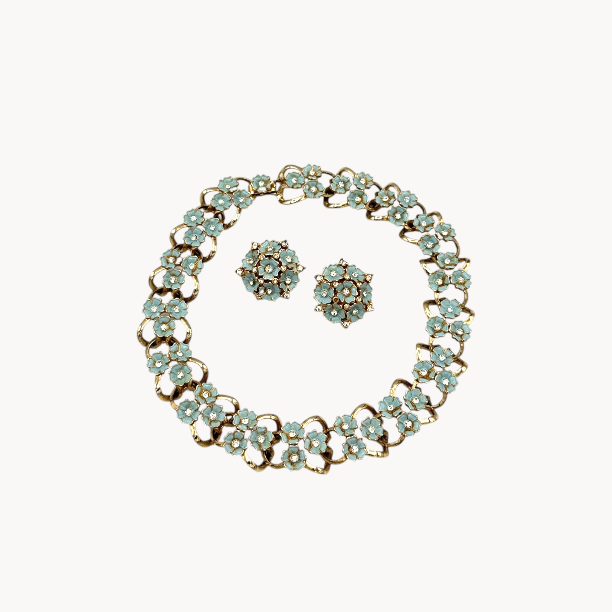 Against white background Vintage mid-century forget-me-not floral necklace and earring set with blue enamel flowers and rhinestones, 1950s bridal jewelry.
