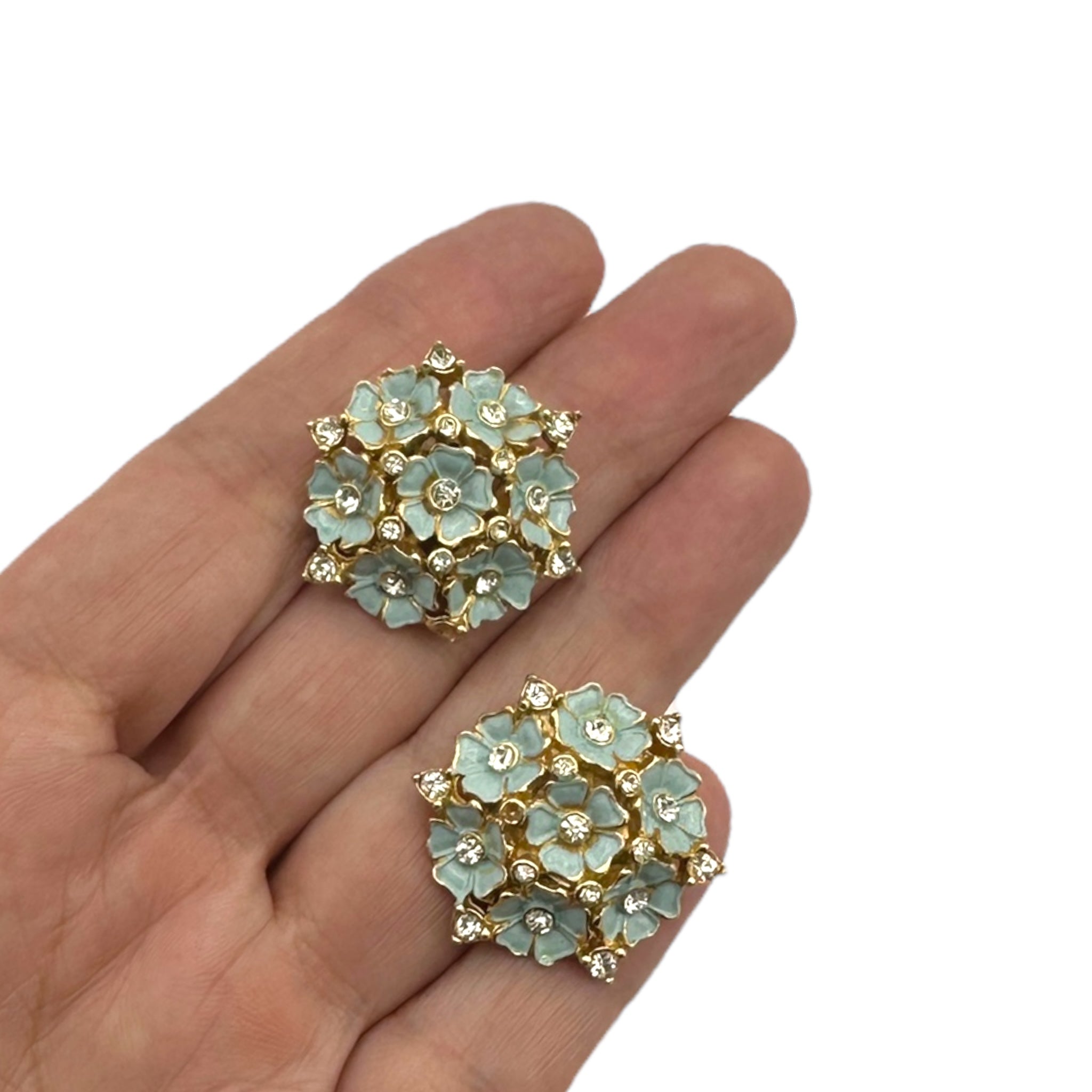 Close up of earrings of Vintage mid-century forget-me-not floral necklace and earring set with blue enamel flowers and rhinestones, 1950s bridal jewelry.