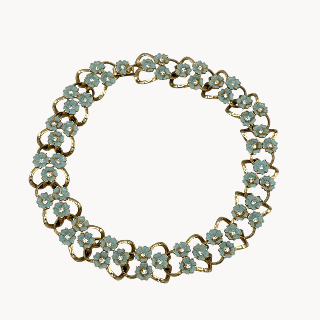 Necklace against white of Vintage mid-century forget-me-not floral necklace and earring set with blue enamel flowers and rhinestones, 1950s bridal jewelry.