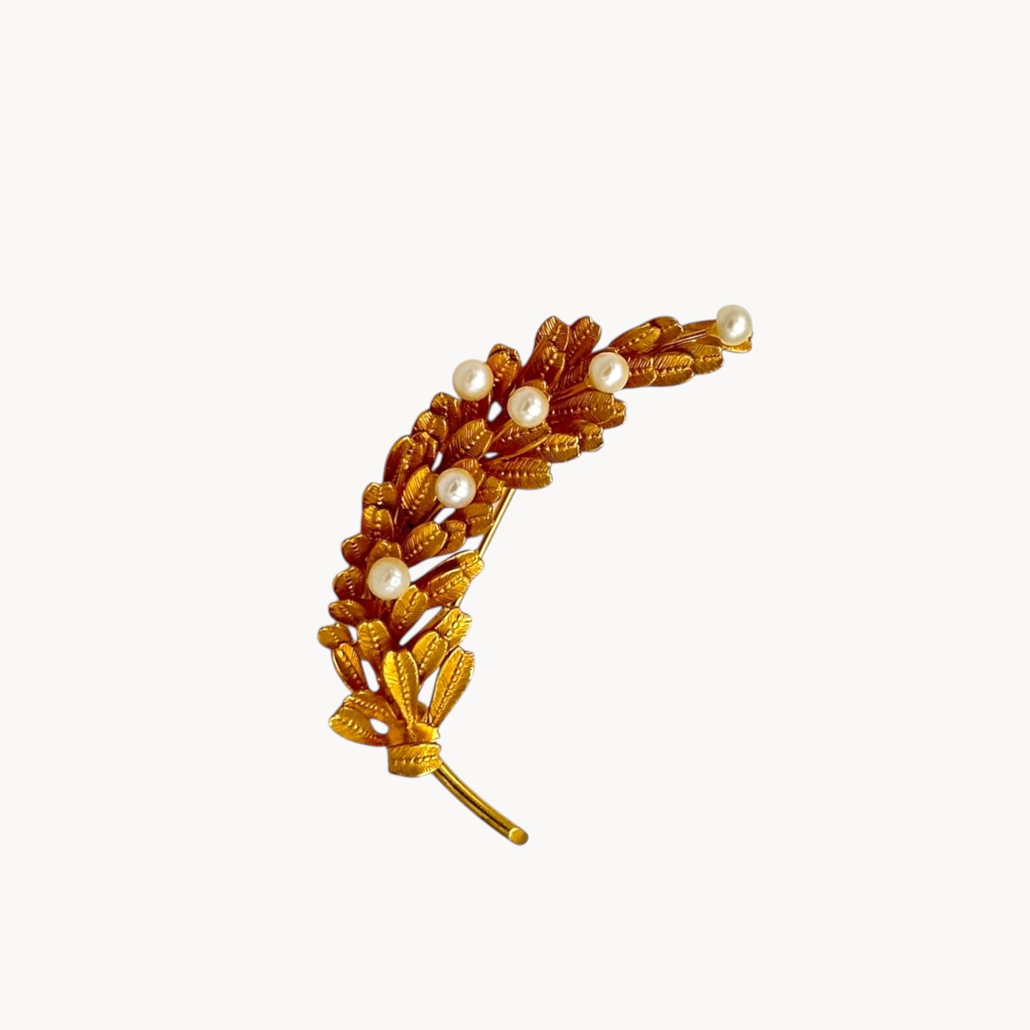 Vintage gold-filled floral brooch with detailed leaf design and real pearl accents, mid-century shown on white background.