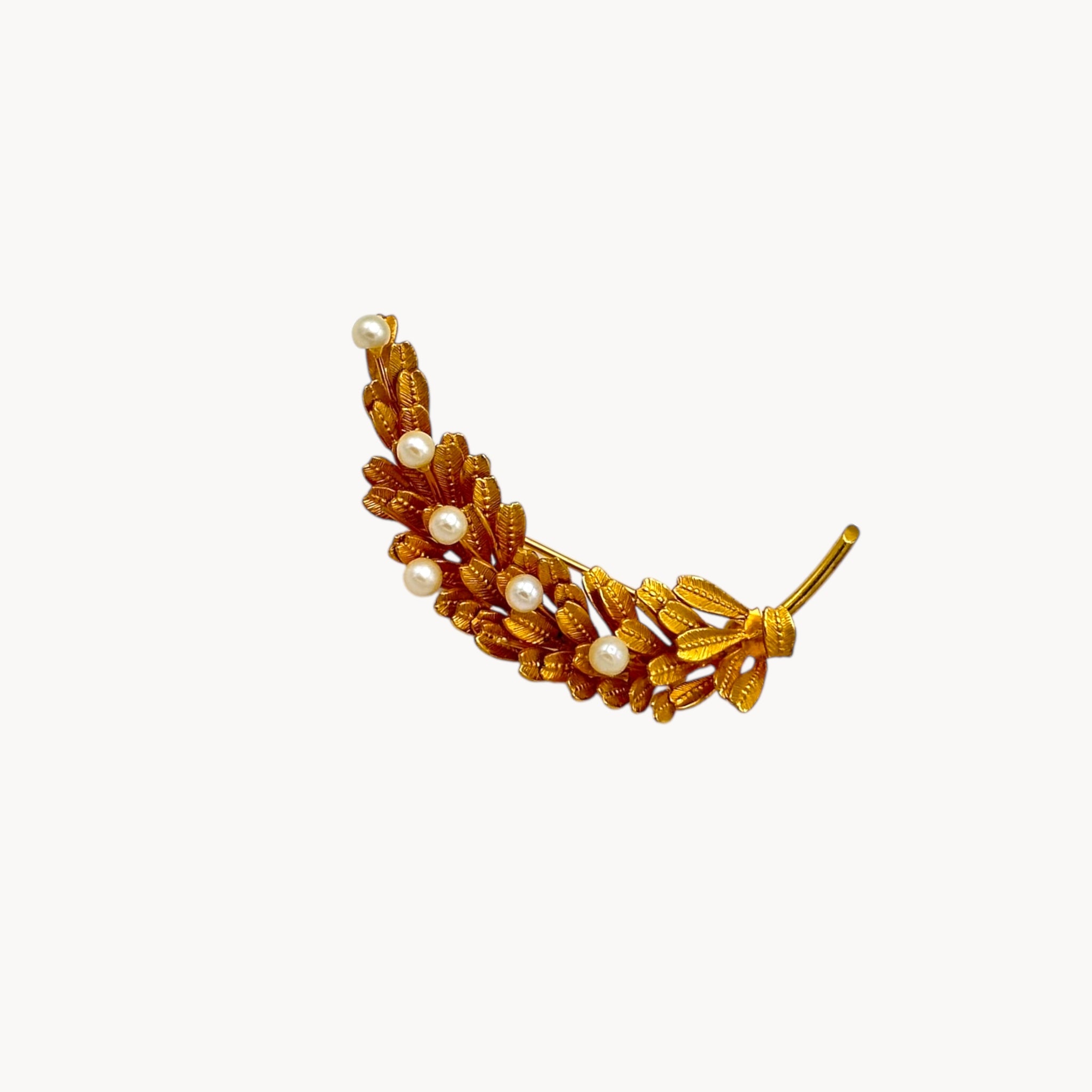 Vintage gold-filled floral brooch with detailed leaf design and real pearl accents, mid-century shown on white background.